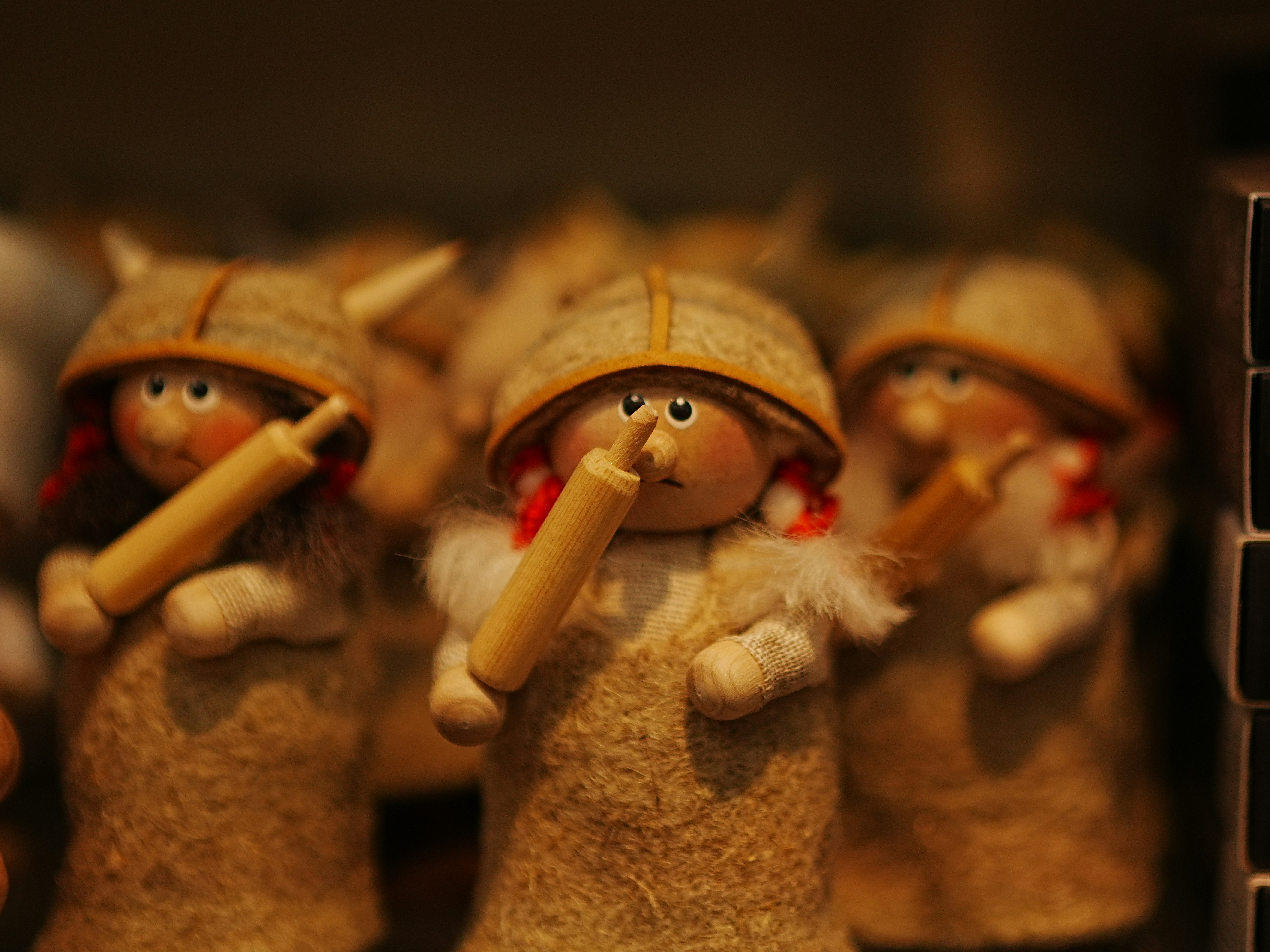 Small wooden figurines wearing felt hats and holding miniature rolling pins
