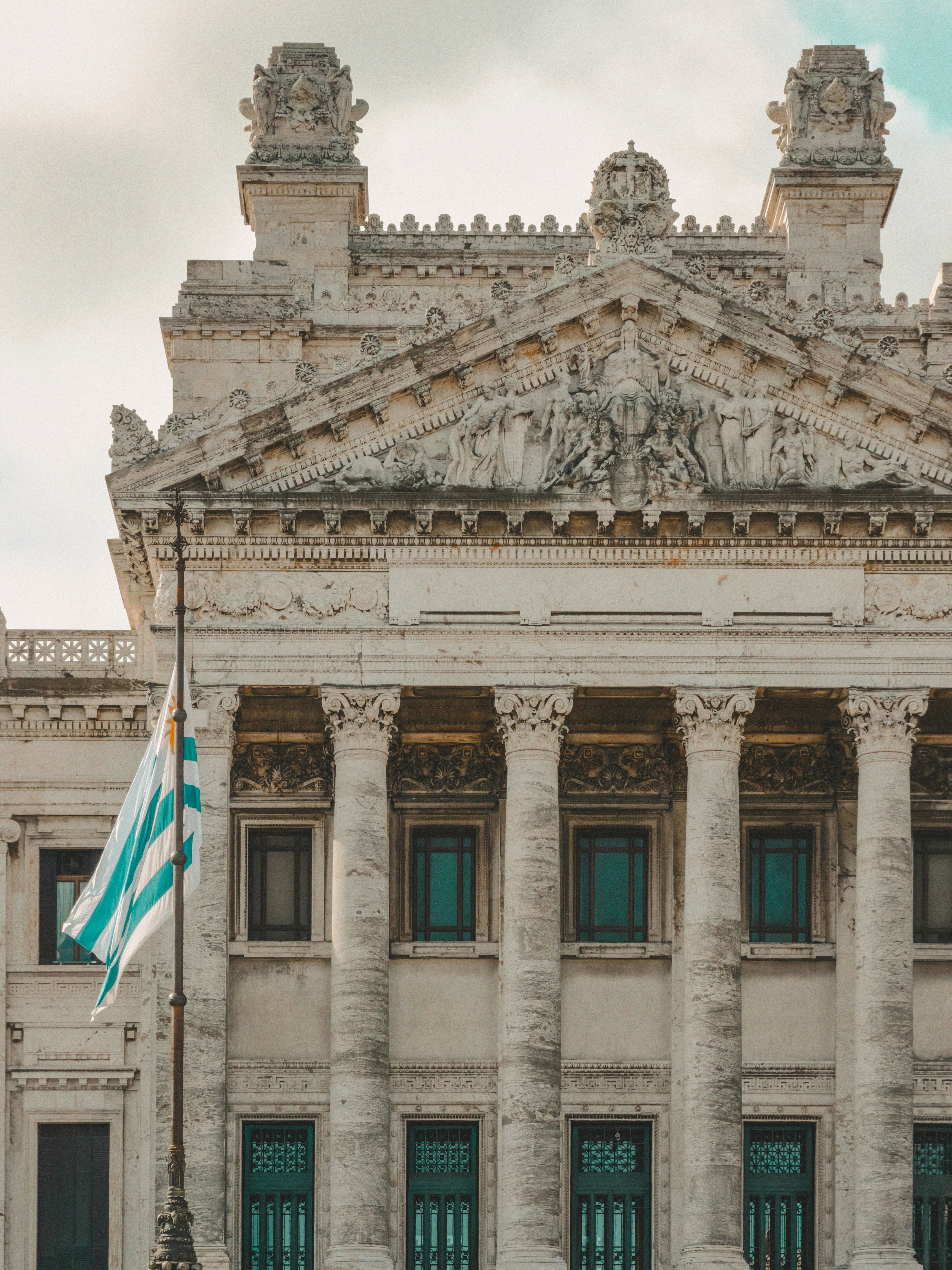 The Legislative Palace with neoclassical columns and a waving flag of Uruguay in Montevideo