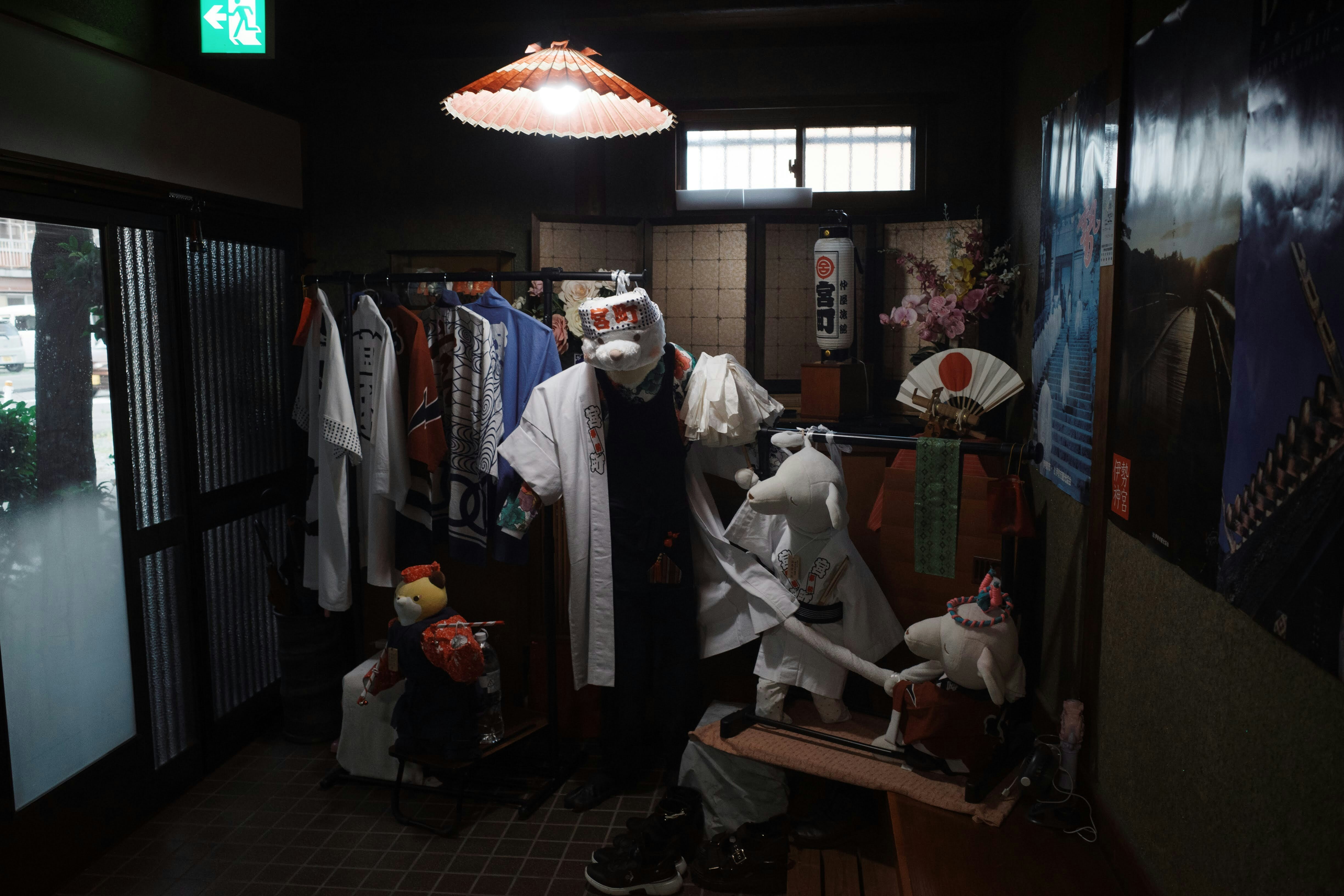 Plush animal figures wearing traditional Japanese festival clothing in a dimly lit room