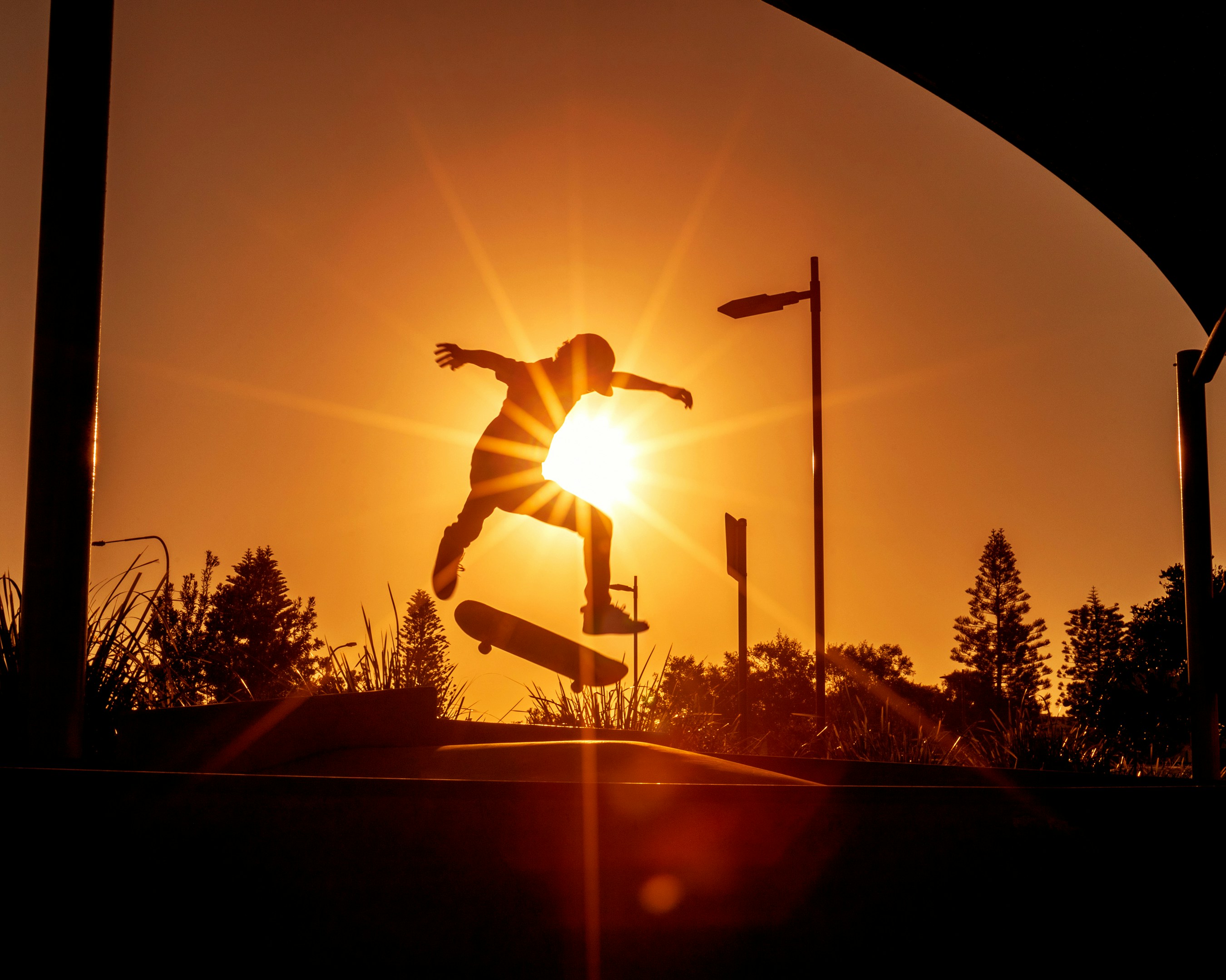 Skater silhouetted against an orange sunset