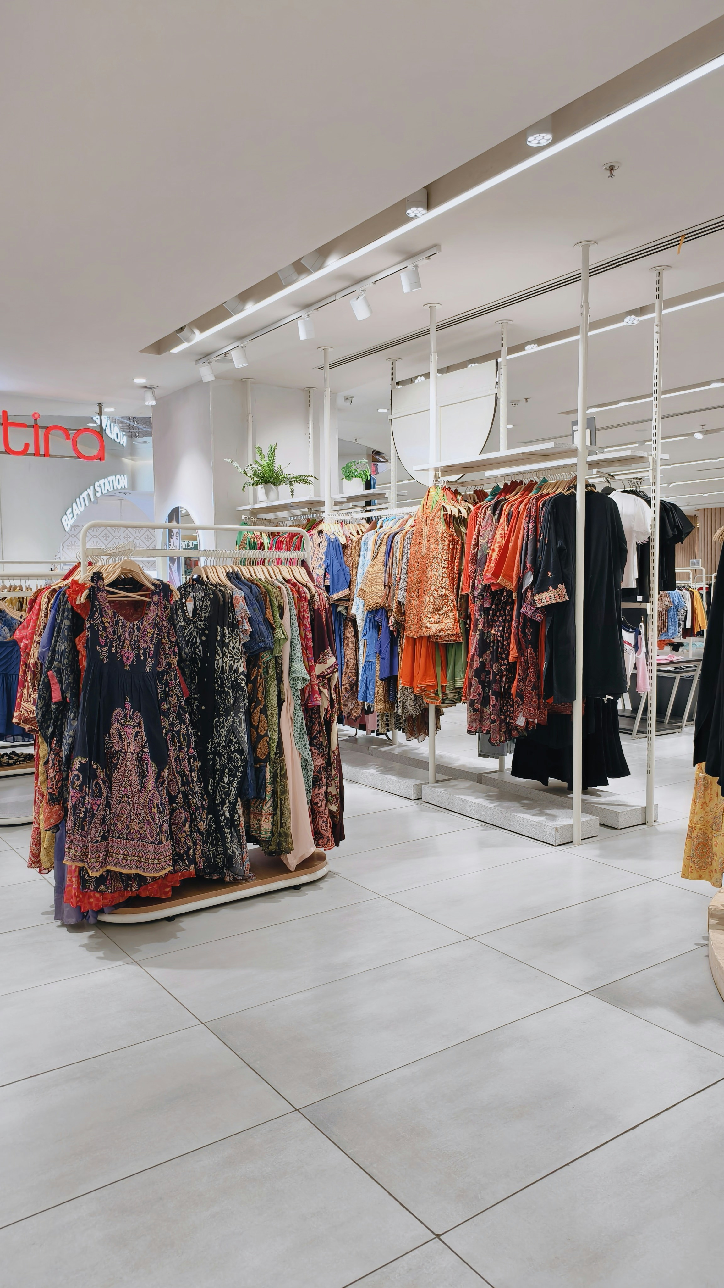 Clothing racks filled with colorful patterned dresses and tunics in a retail store