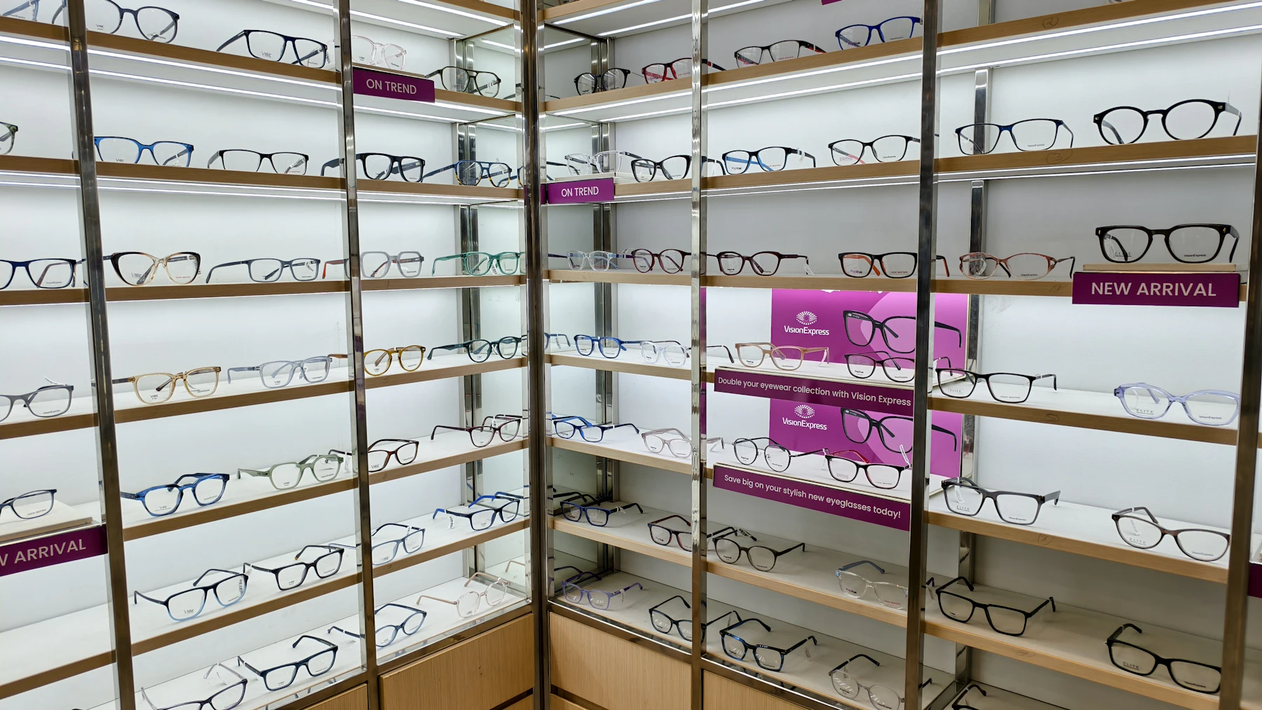 Rows of eyeglasses on illuminated shelves
