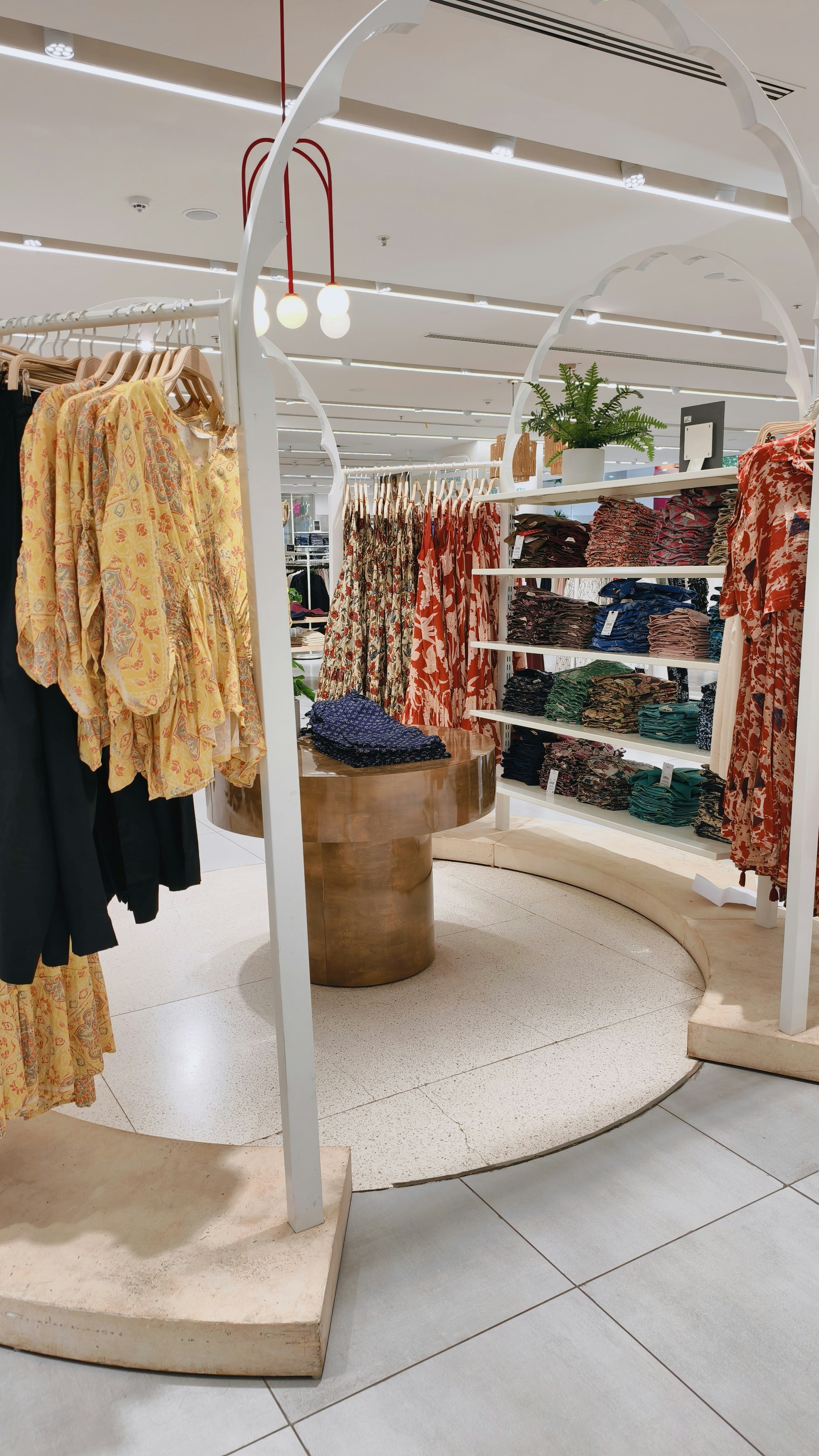 Clothing racks and shelves with folded garments in a bright retail store