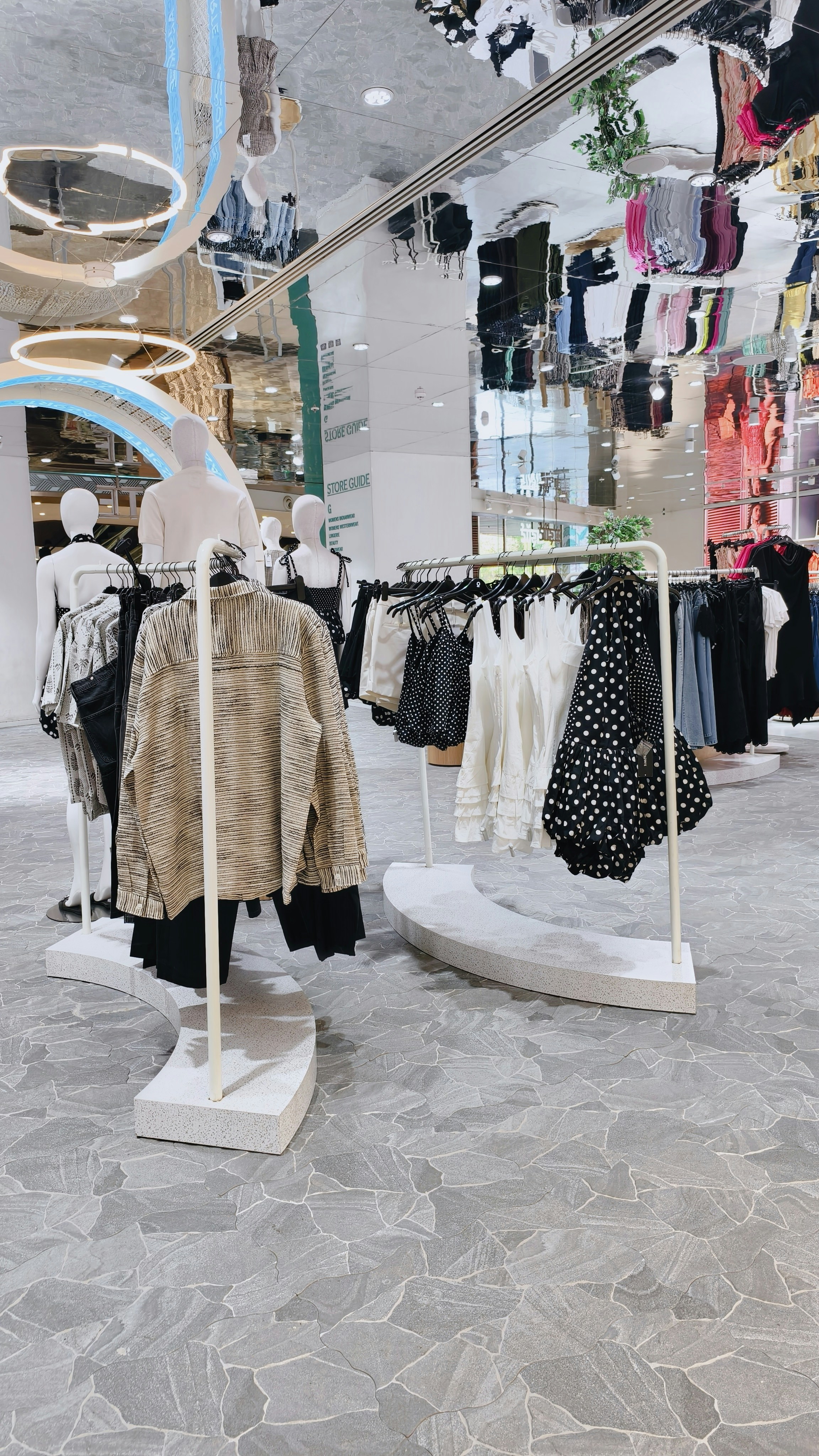 Clothing racks with shirts and dresses in a modern retail store