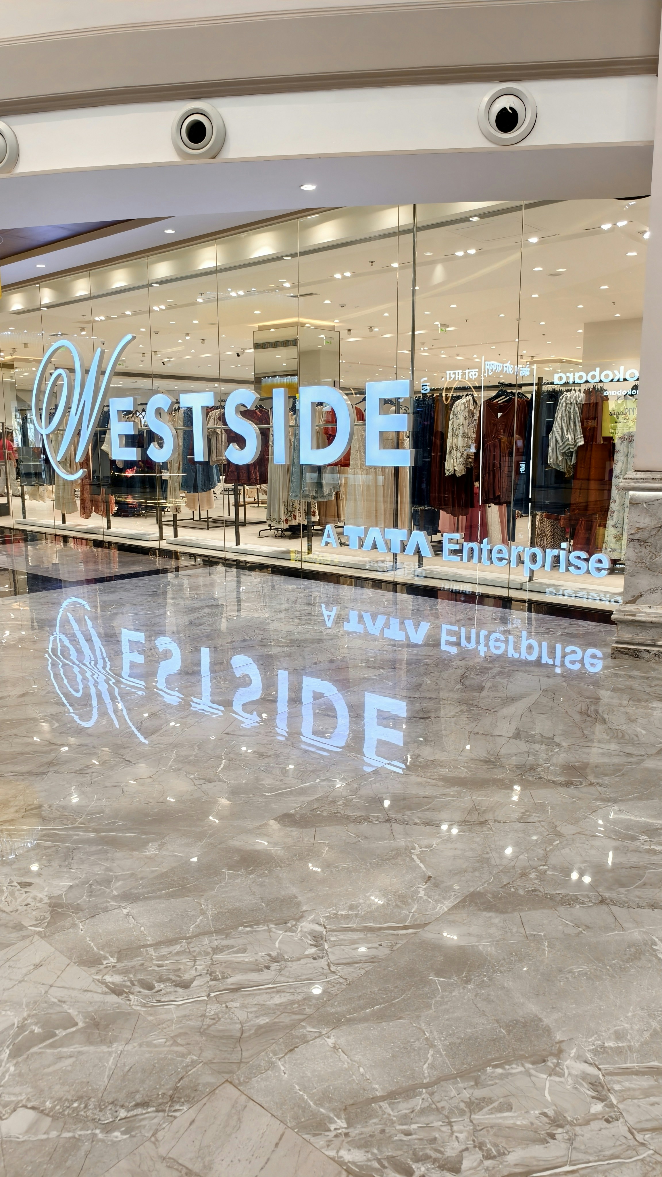 A Westside store entrance with glass walls and a polished marble floor