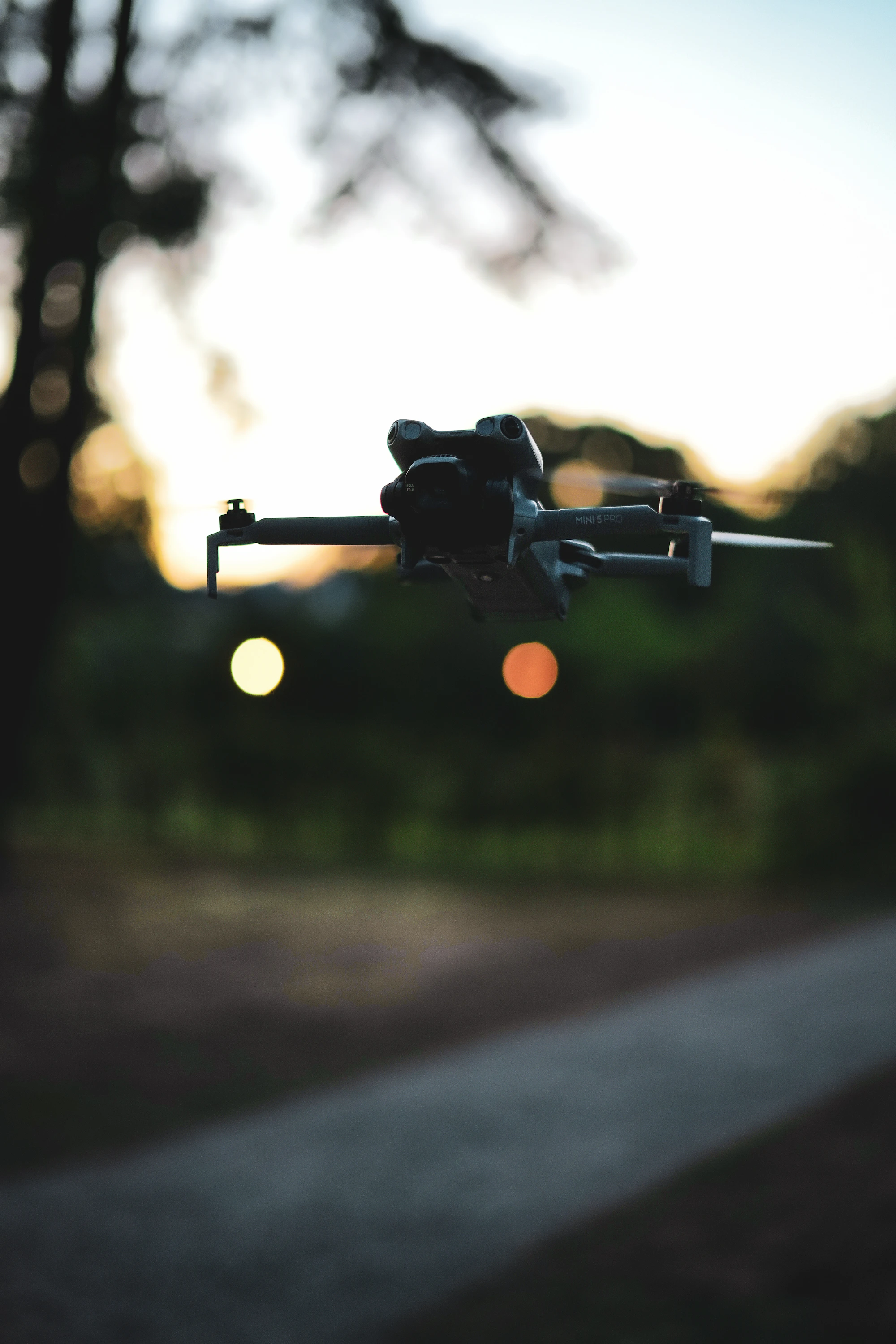 A DJI Mini 5 Pro hovering at dusk