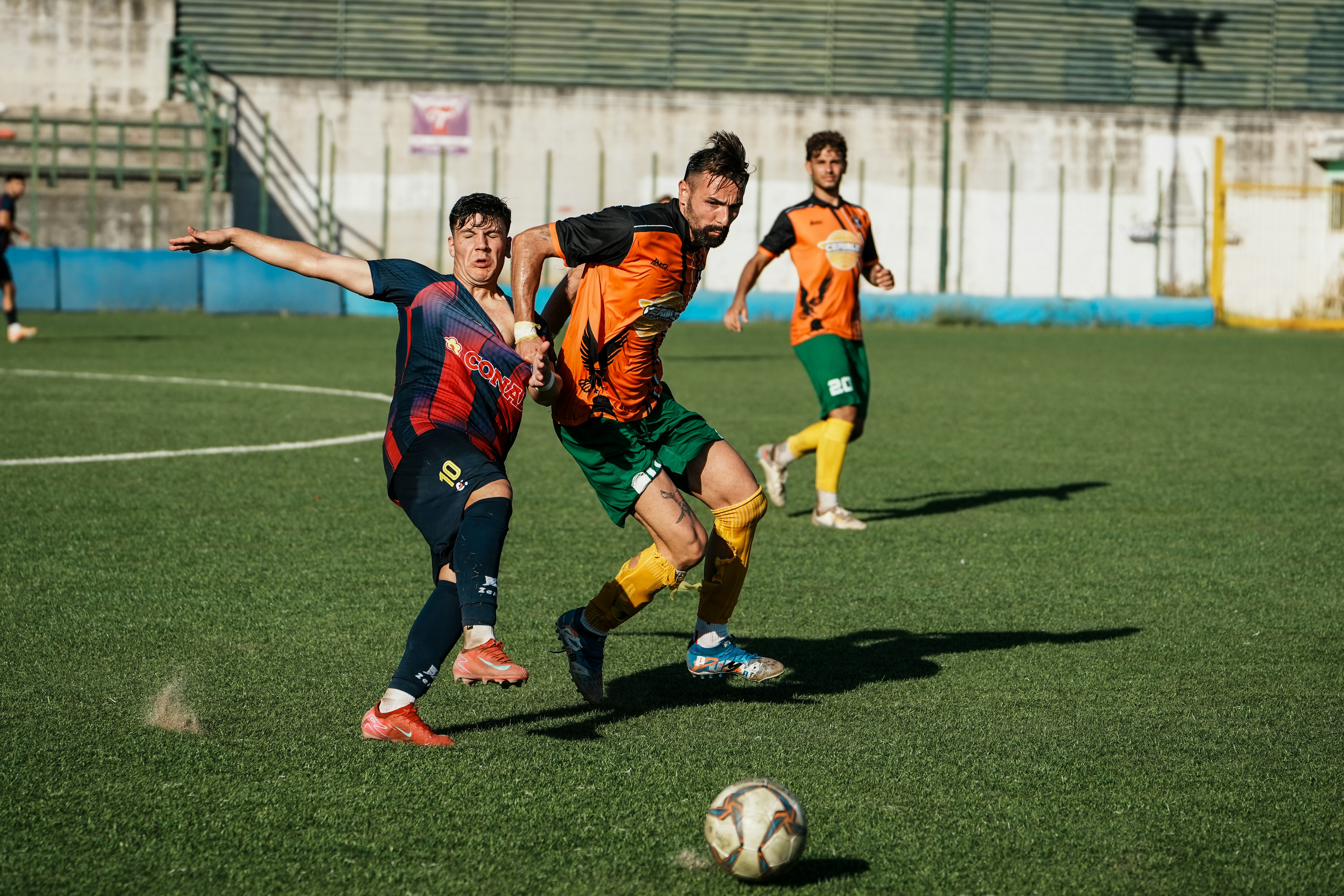 Two soccer players competing for the ball on a green grass field