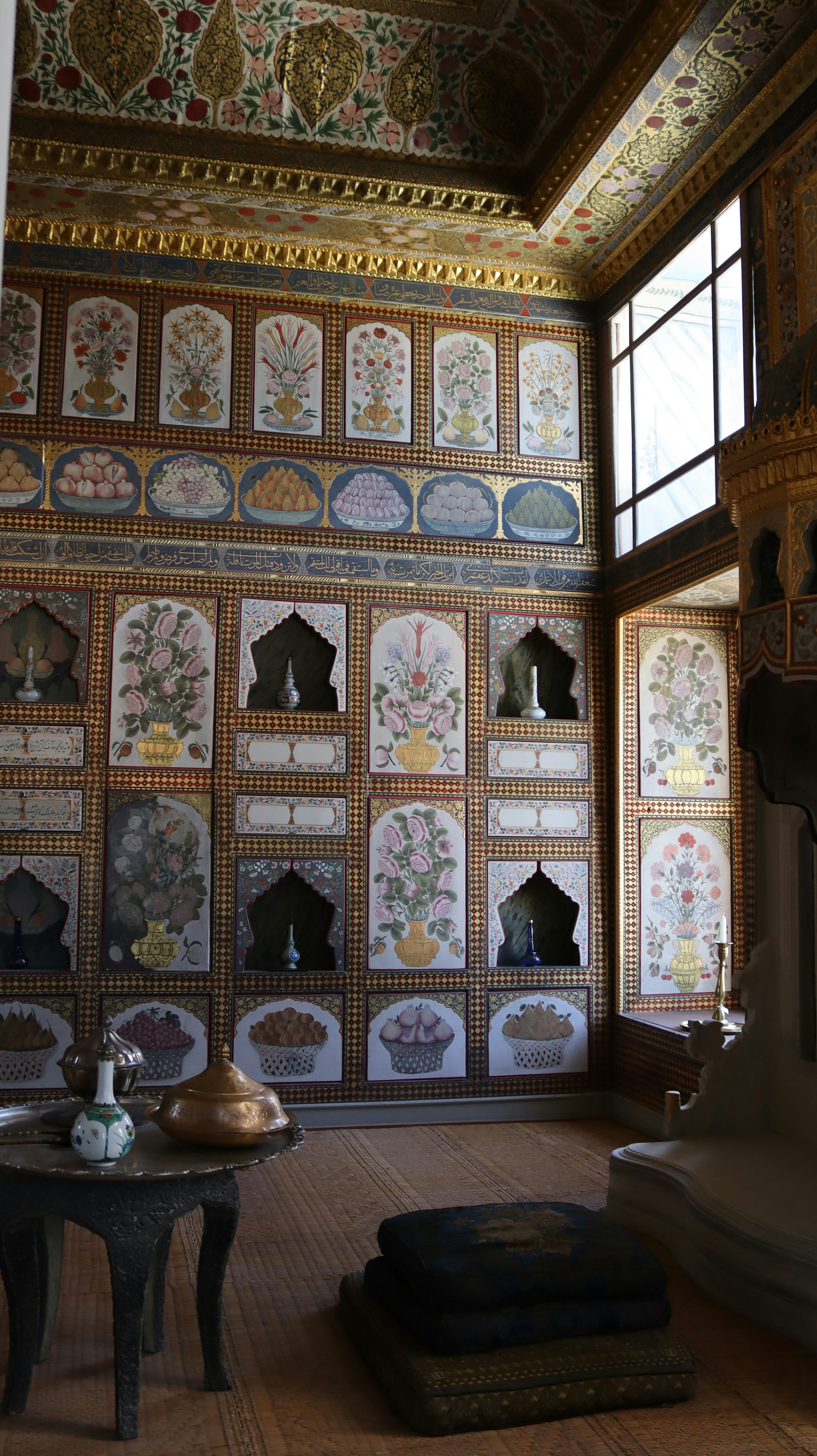 Ornate wall panels with floral paintings and niches in a historic room