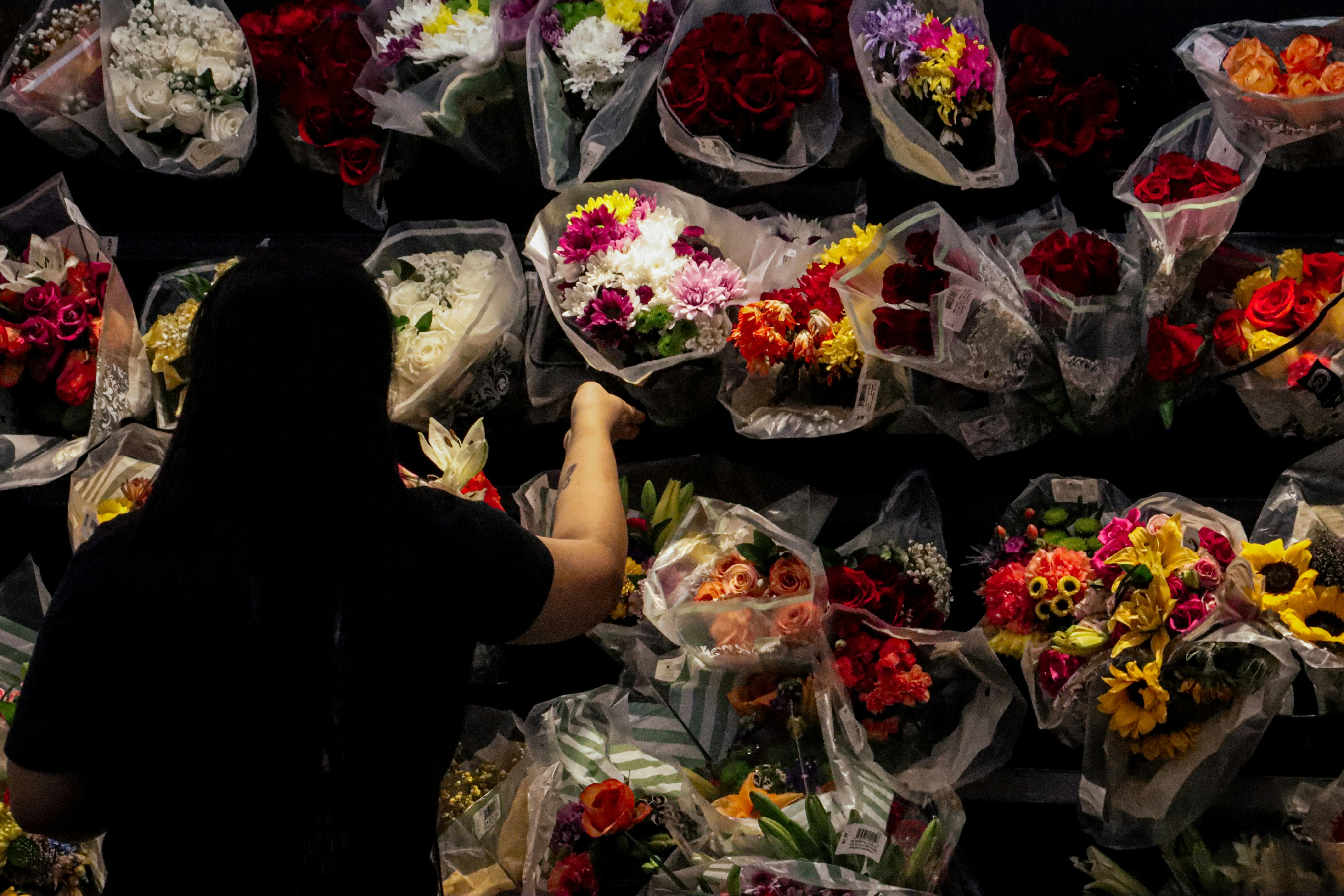Person reaching for a bouquet at a flower market
