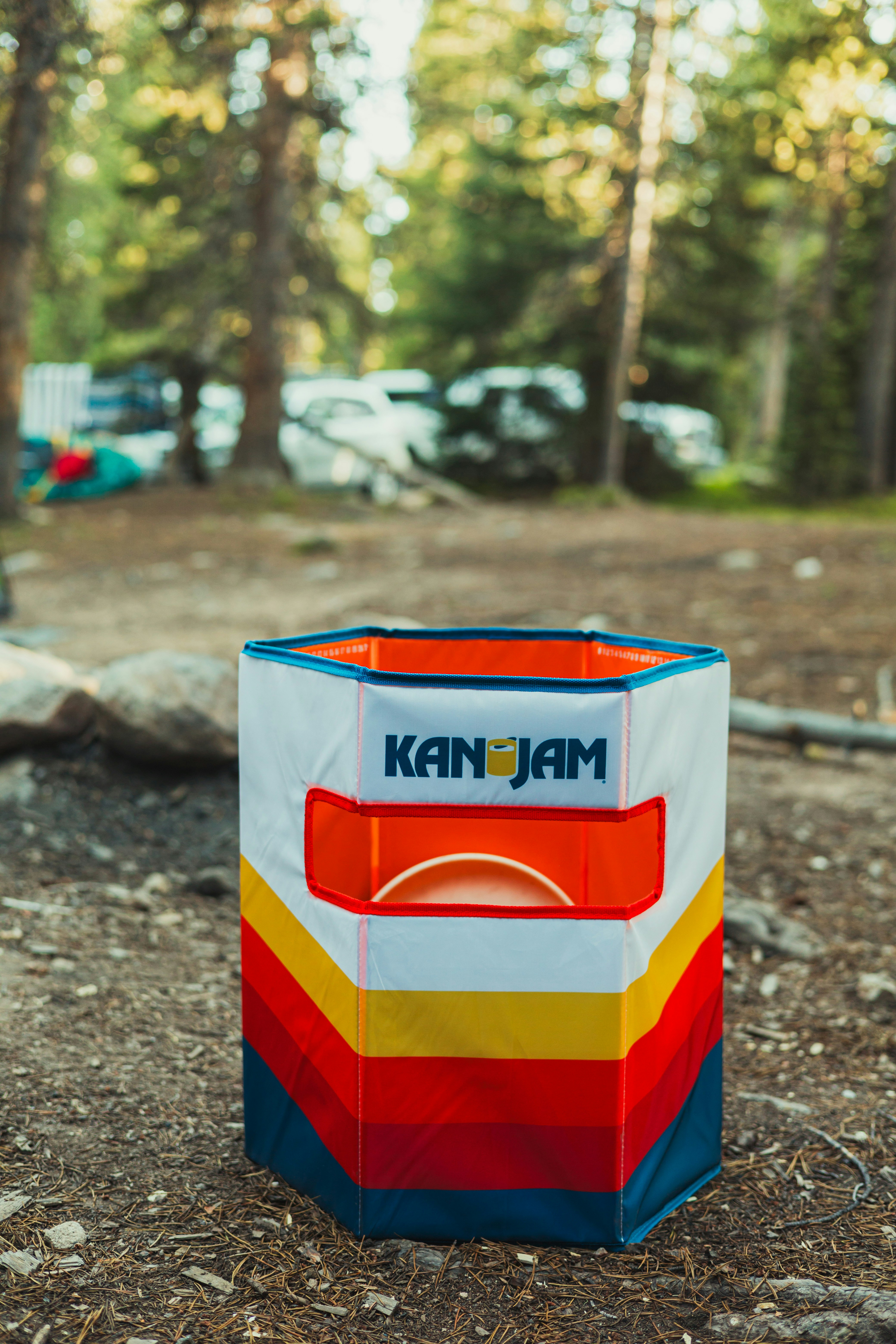 A KanJam game goal with a frisbee inside on a forest floor