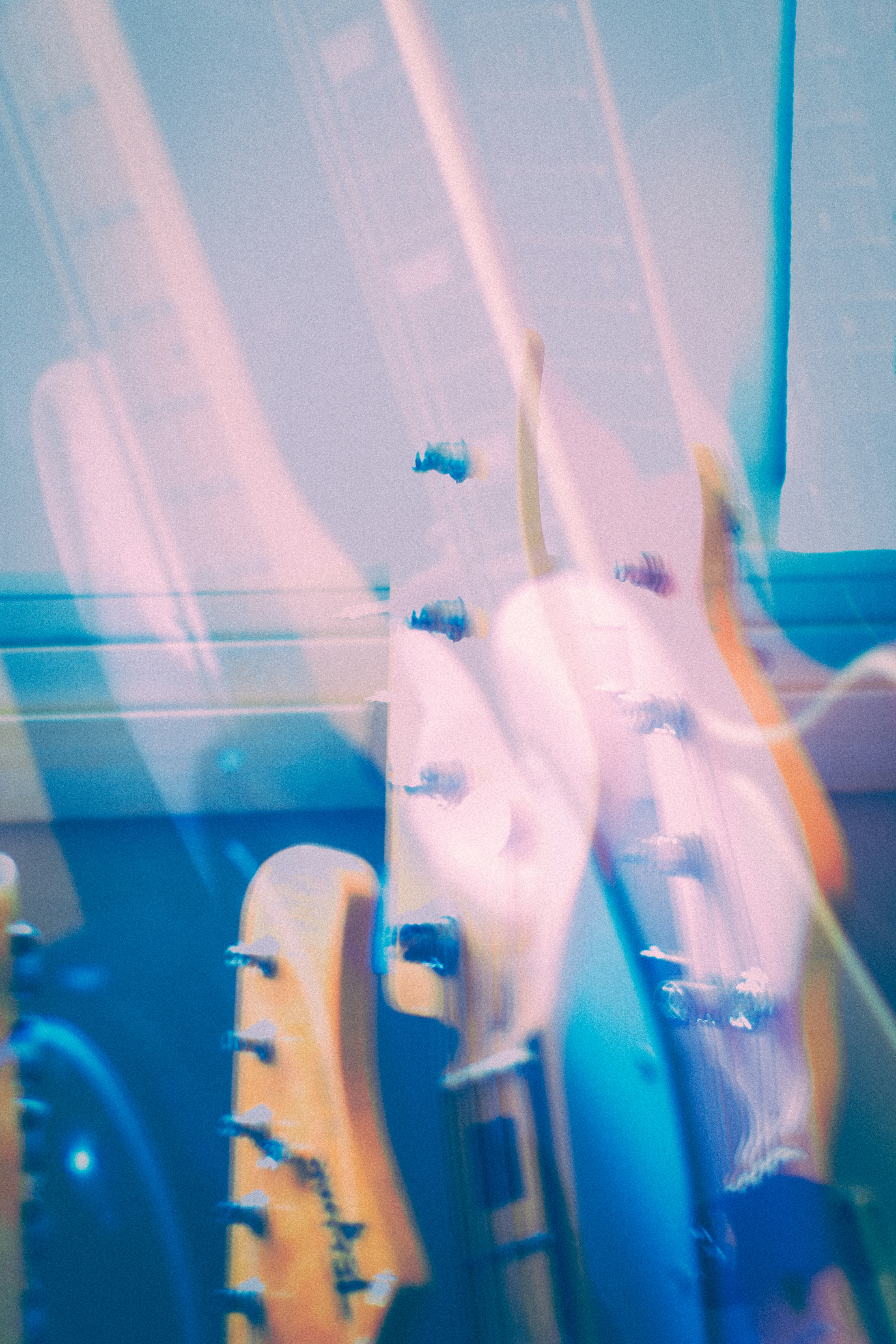 Dupla exposição dos headstocks de guitarra elétrica em luz azul e rosa