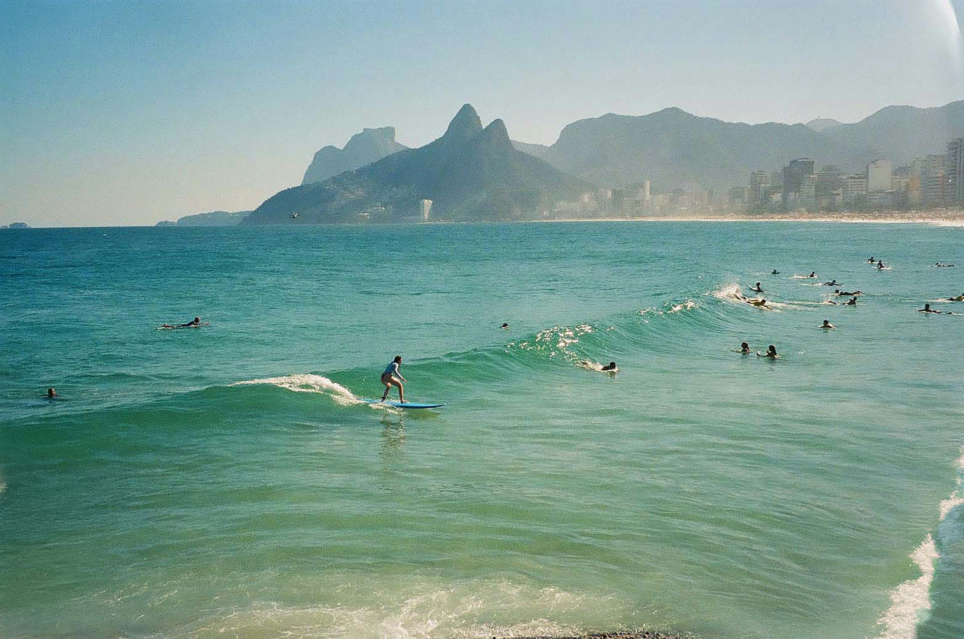 A person surfing on a blue board at Ipanema Beach in Rio de Janeiro