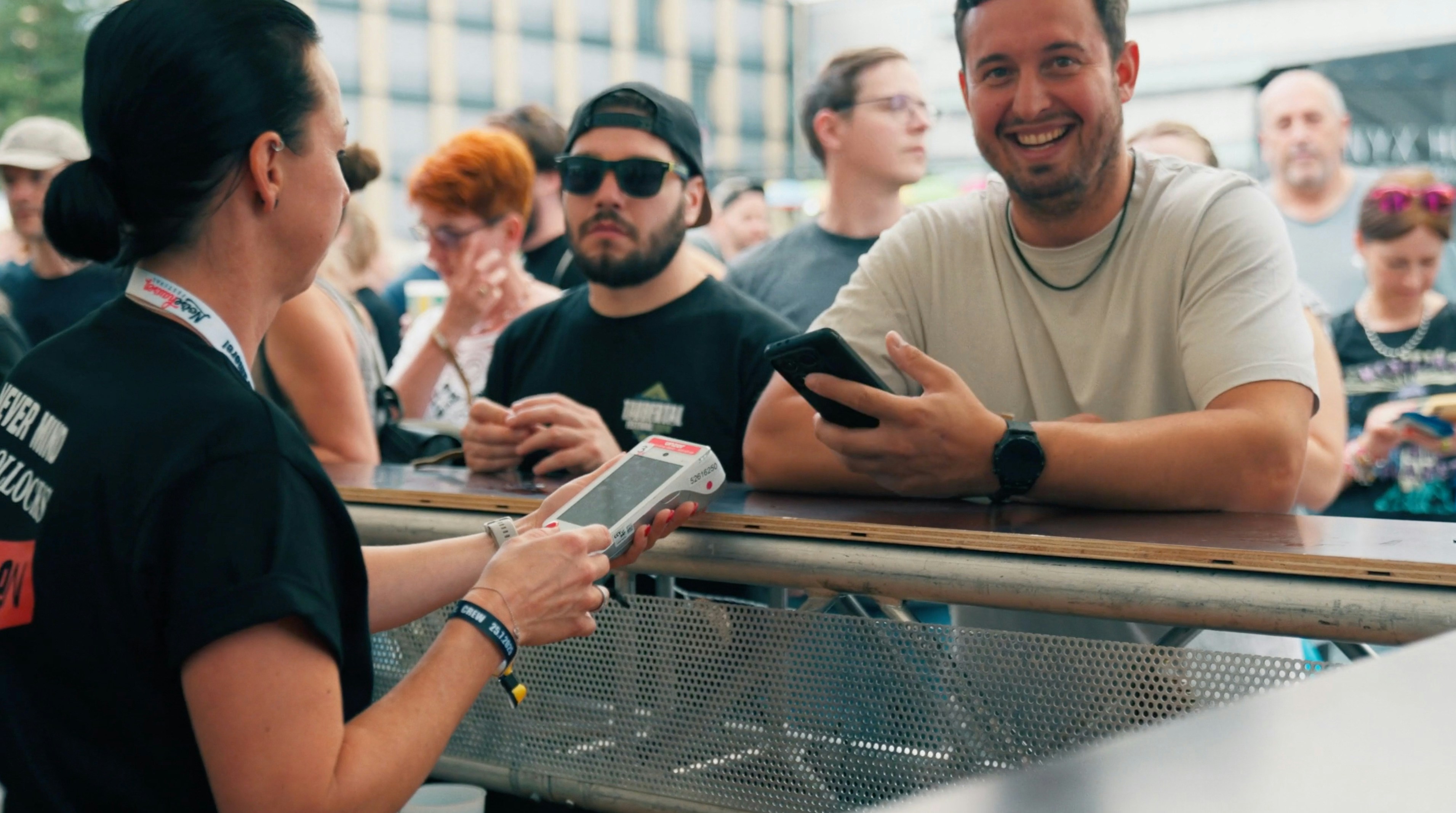 Group at an outdoor table paying with a terminal