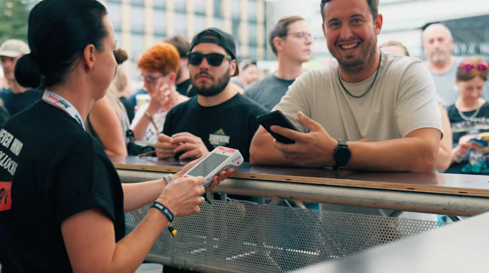 Festival staff holding a payment terminal for a customer