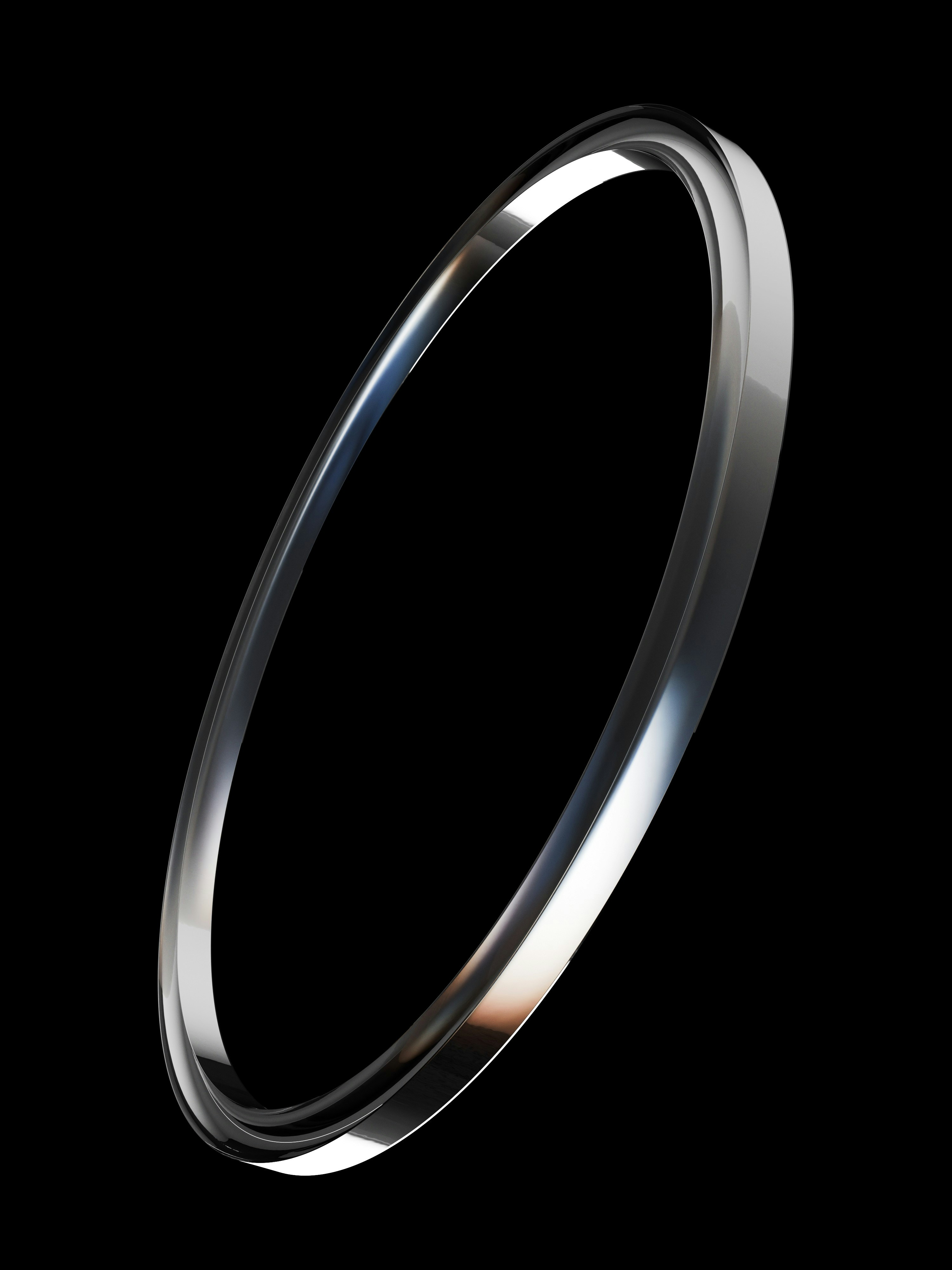 A polished silver ring tilted against a solid black background