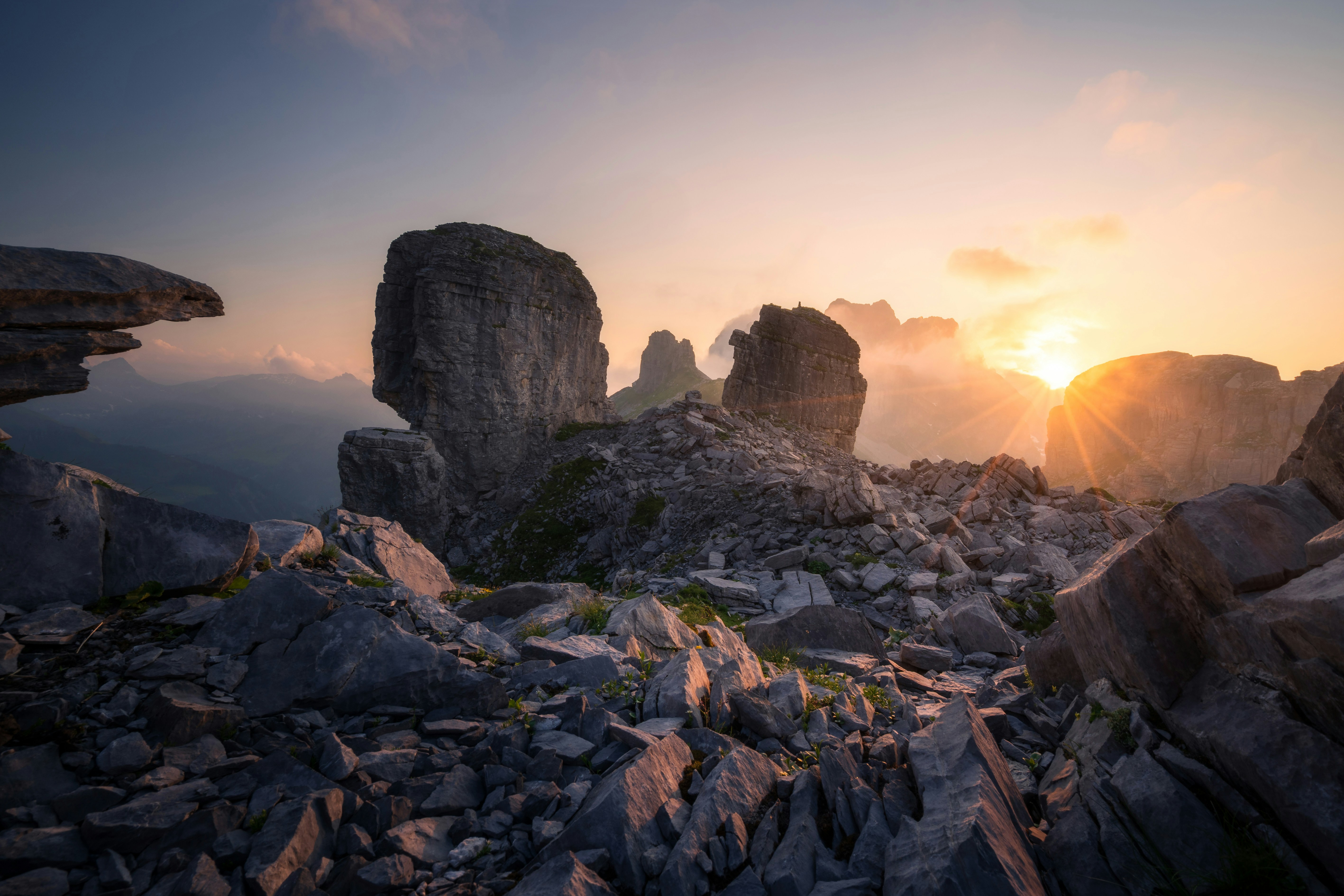 Large rock formations on a mountain ridge under a warm low sun