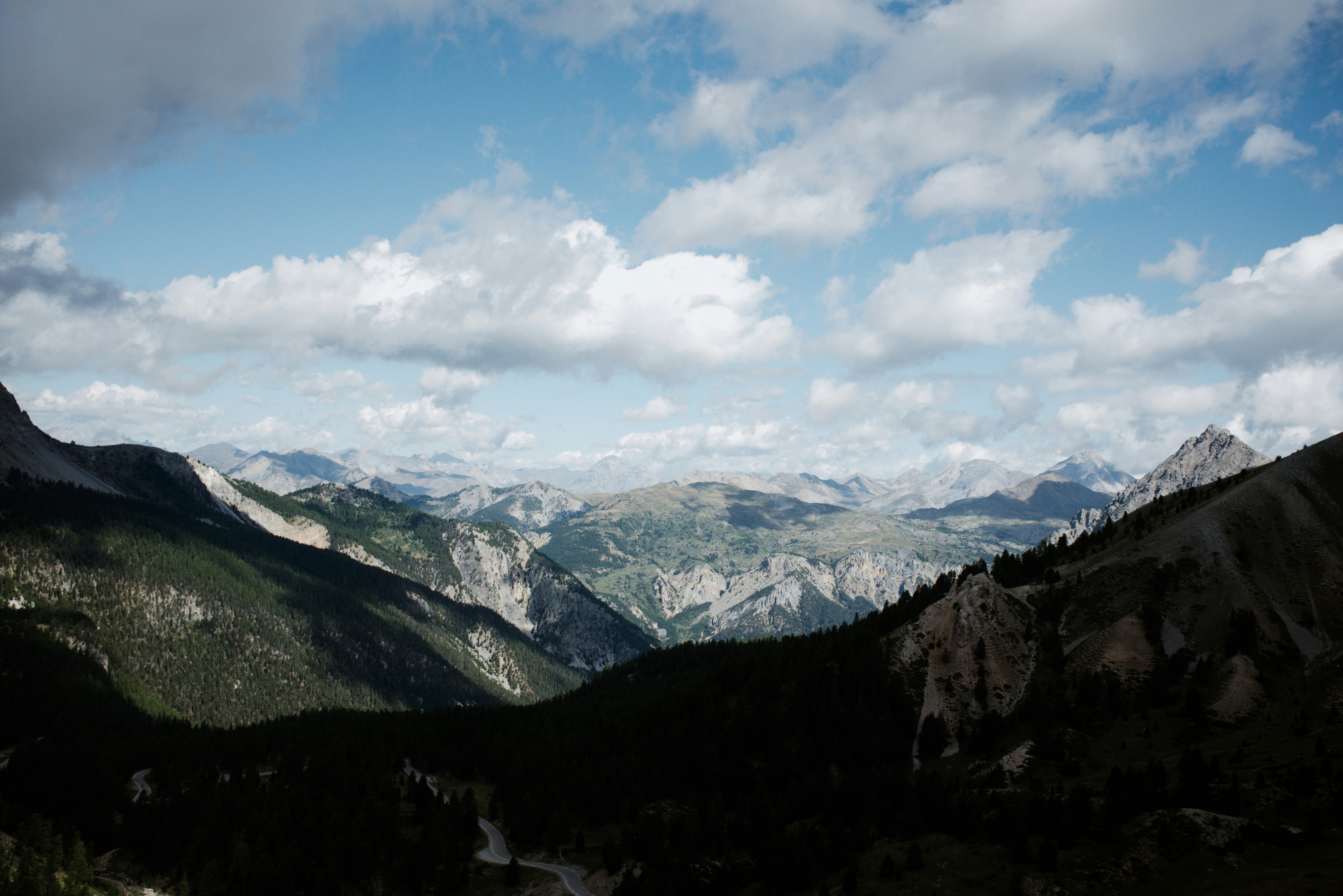 A winding road through a deep valley surrounded by rugged mountain peaks