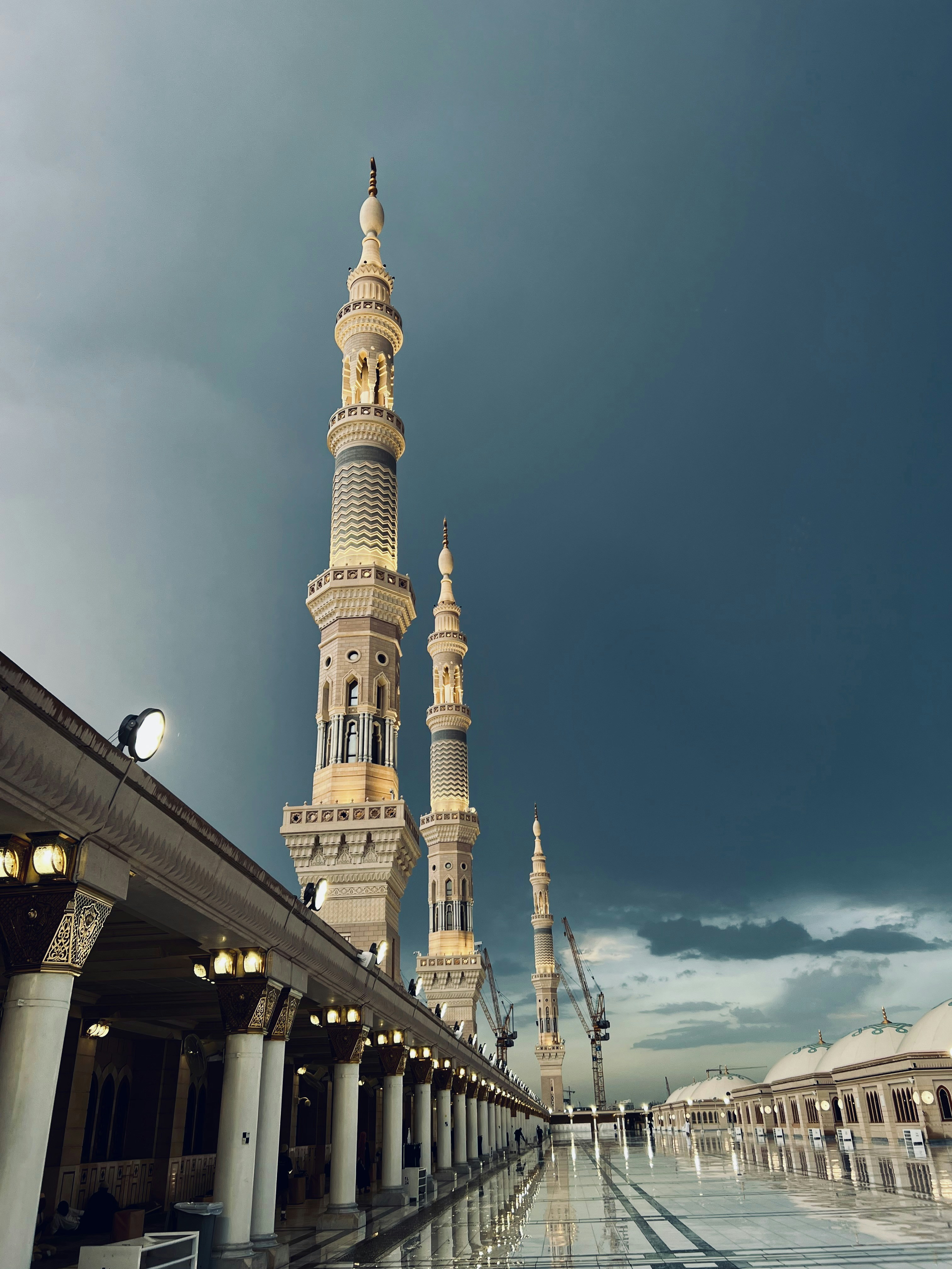 Três altos minaretes da Mesquita do Profeta em Medina sob um céu escuro e nublado