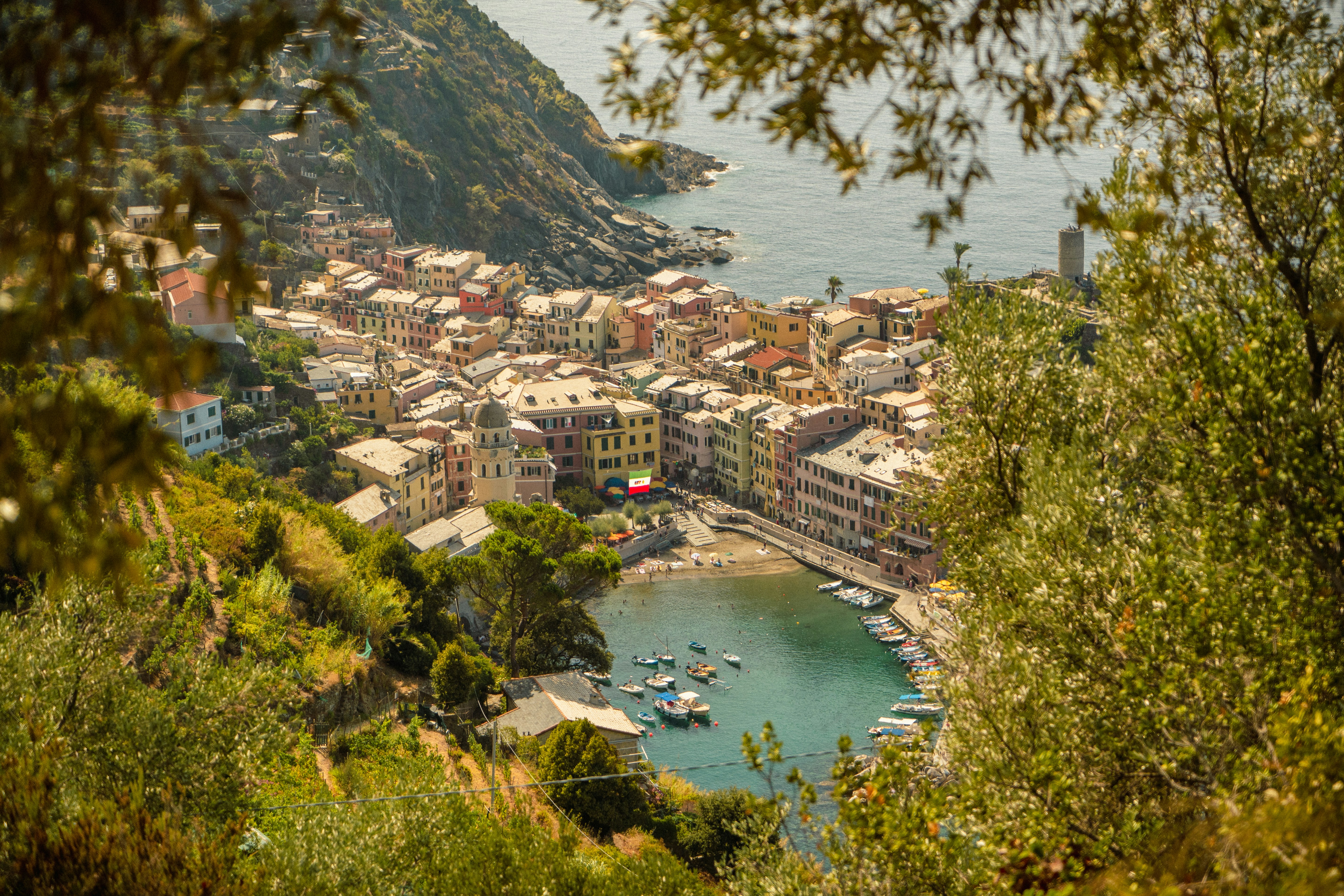 Colorful houses surrounding a small harbor with boats in Vernazza, Italy