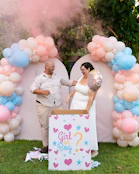 A man and a woman laughing during a gender reveal party outdoors
