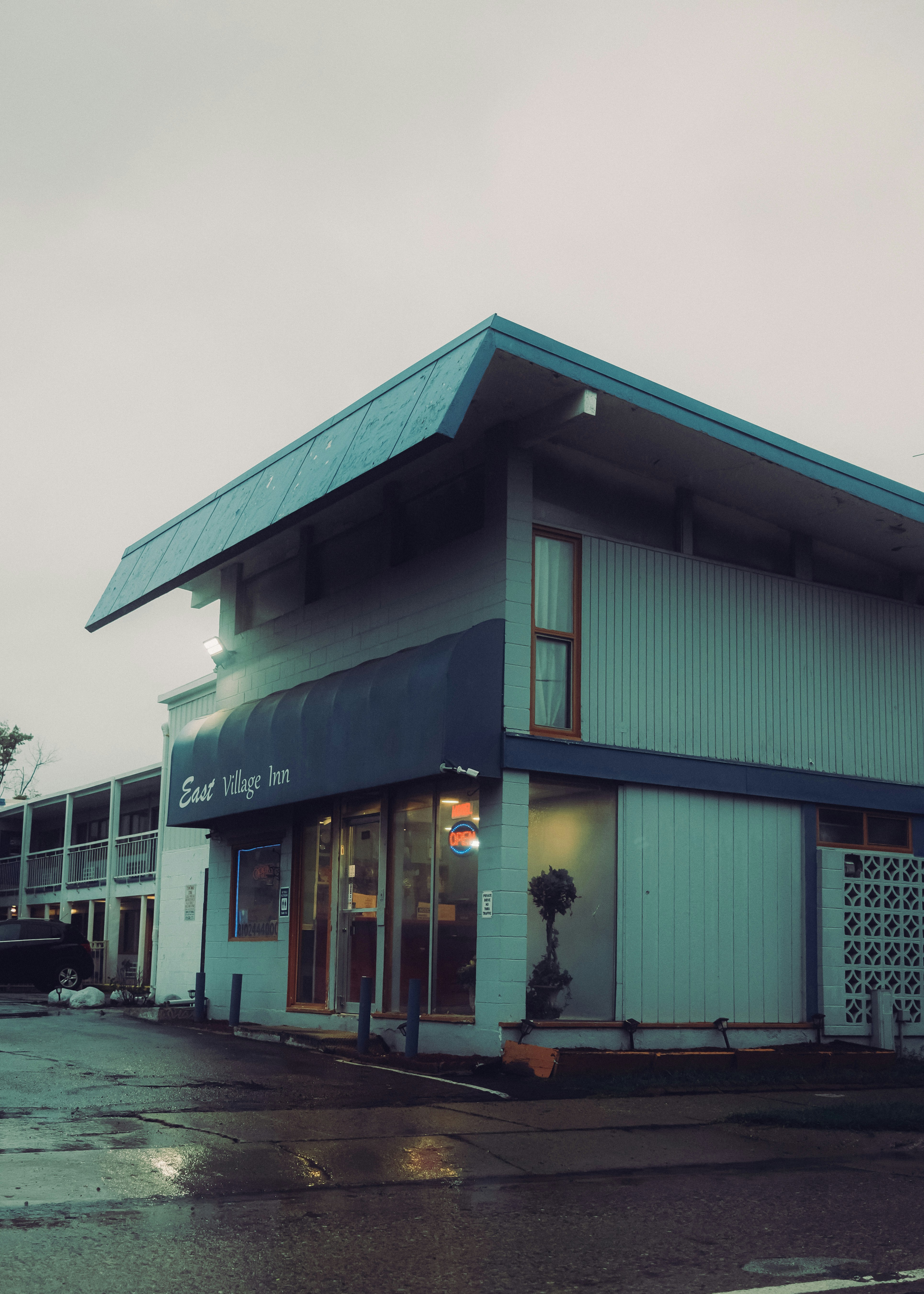 The East Village Inn motel with a blue awning and an open sign