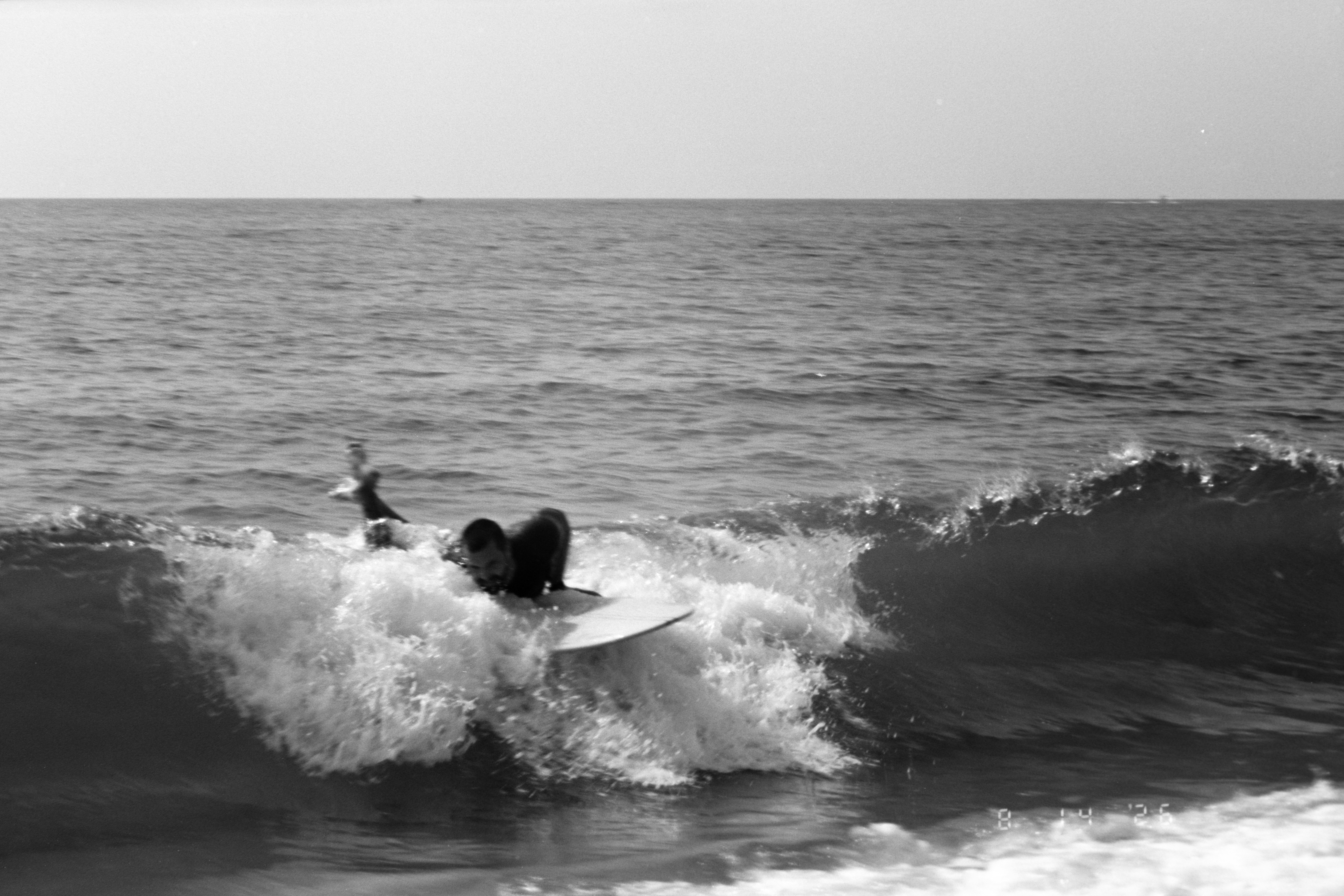 Una persona surfeando en una ola en el océano en blanco y negro