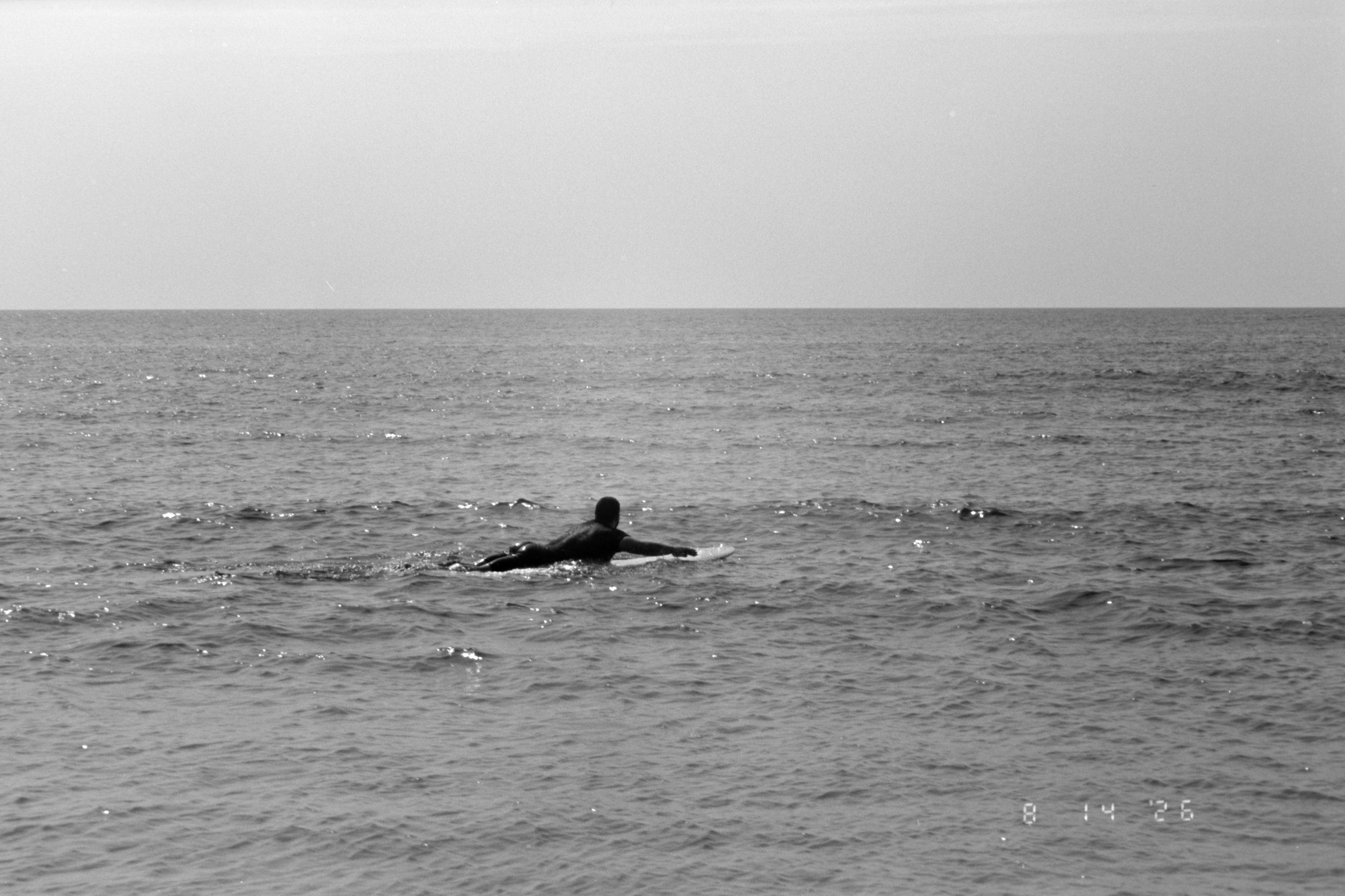 A person paddling on a surfboard in the open ocean