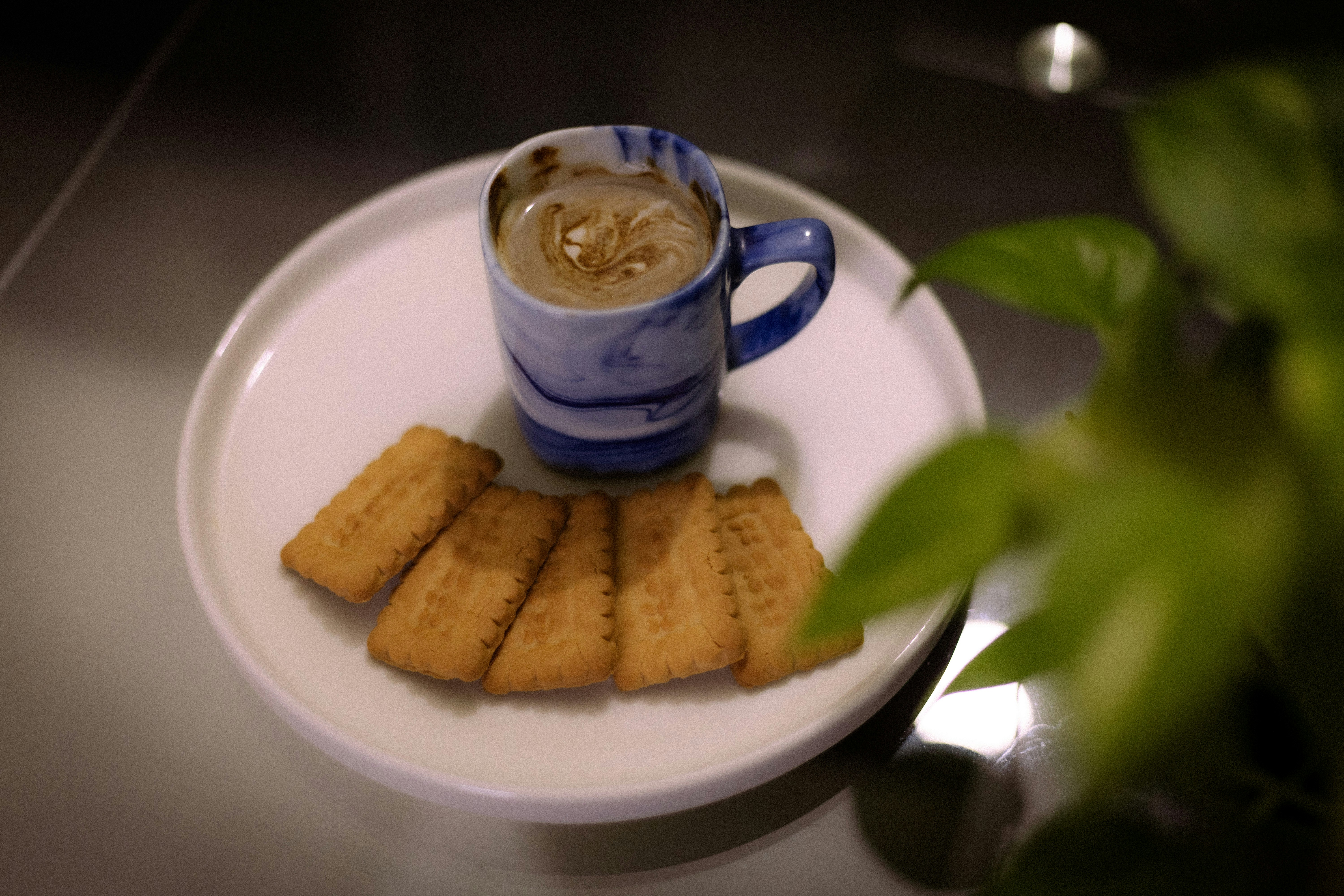 Coffee in a blue marbled mug with biscuits
