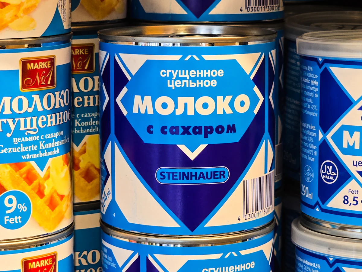 A blue and white tin of sweetened condensed milk on a store shelf