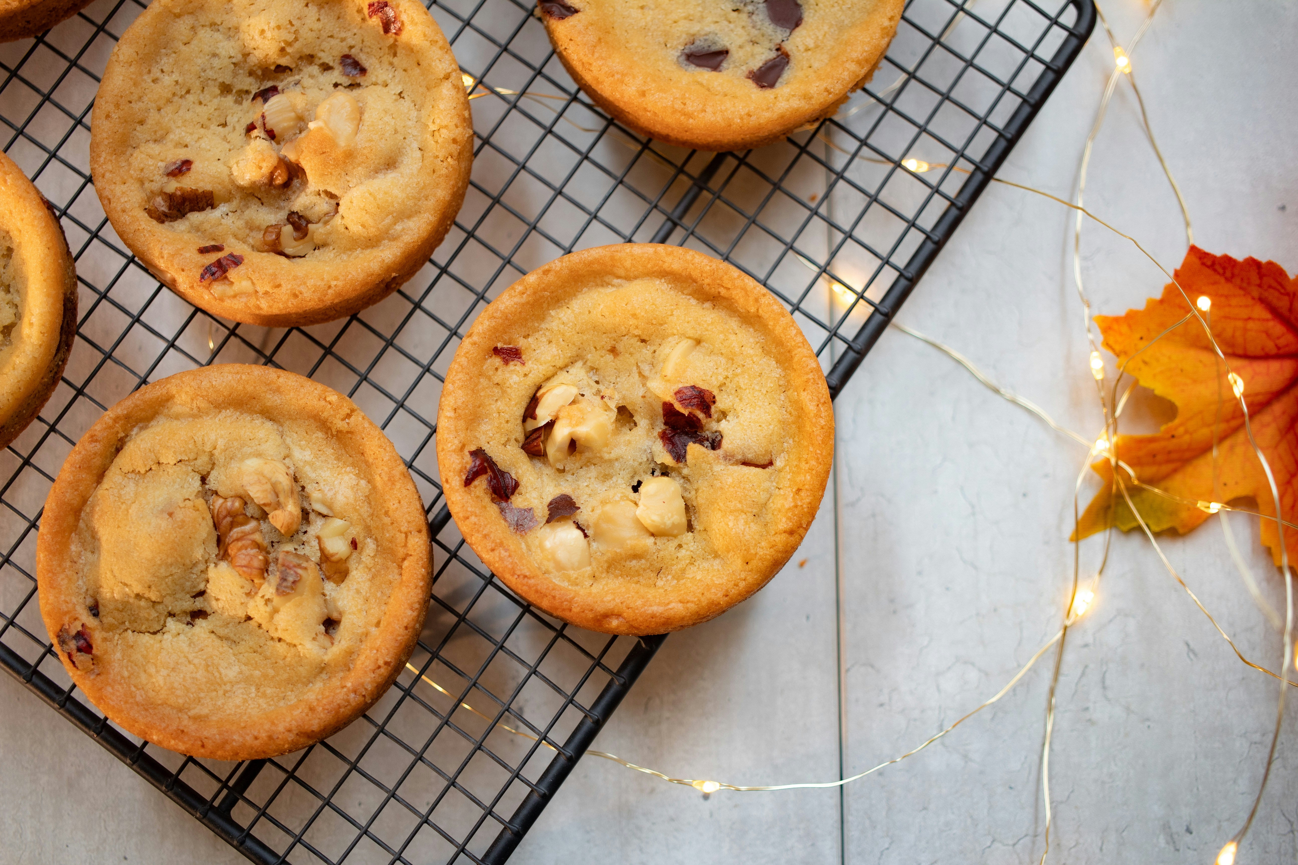 Round cookie cups with nuts and chocolate on a wire cooling rack