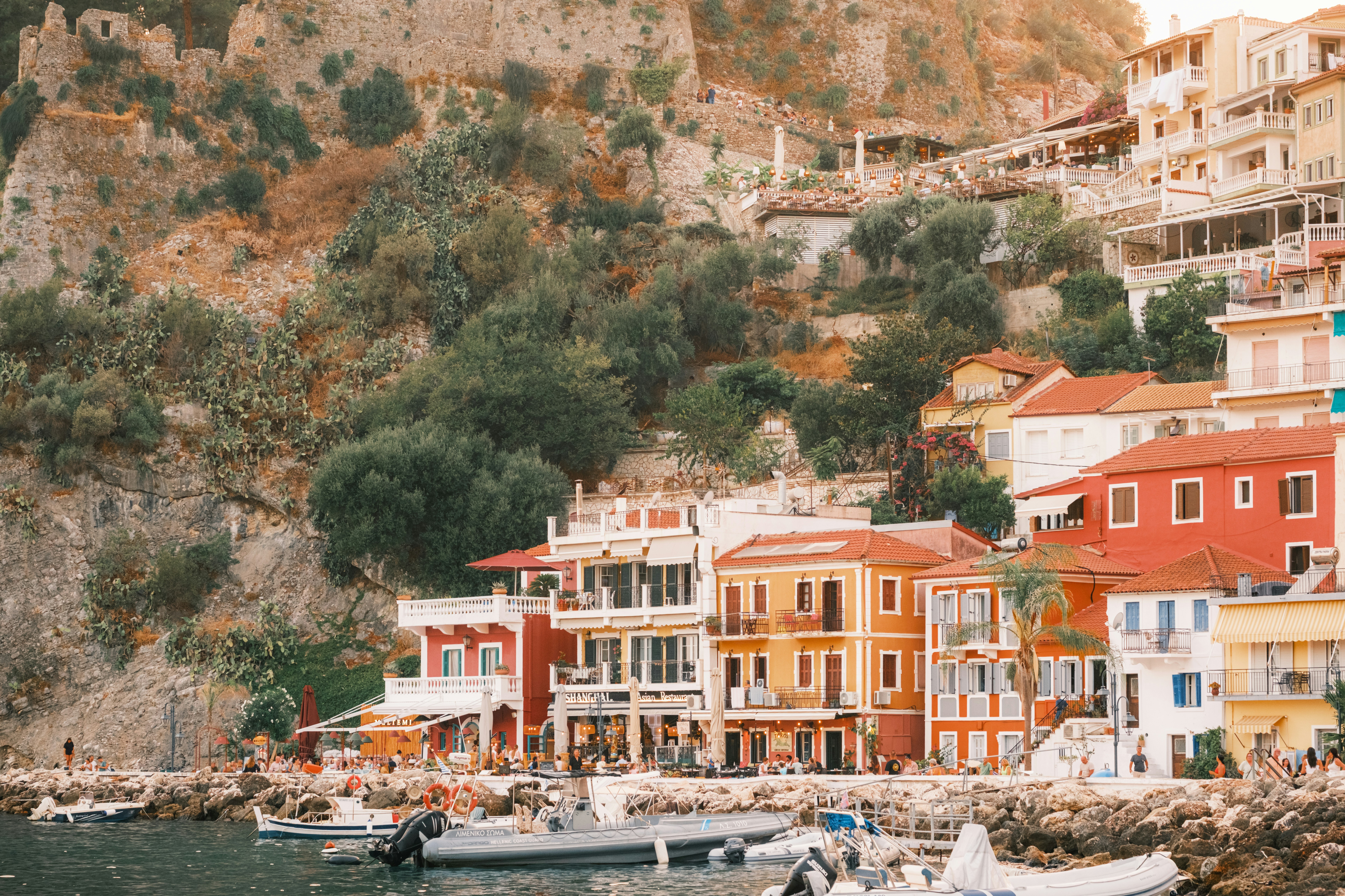 Colorful buildings along a rocky coastline with boats moored in the water