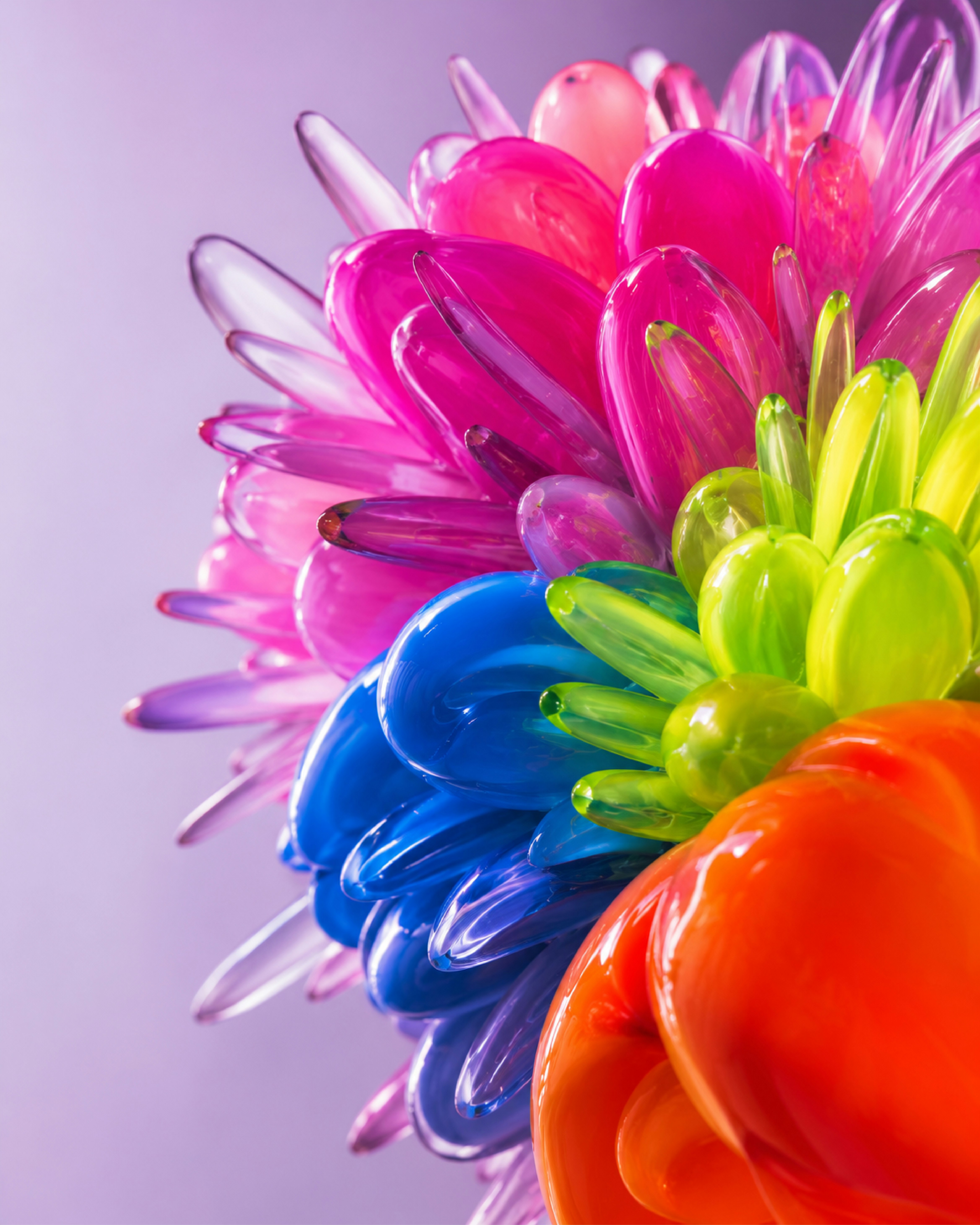 A cluster of translucent pink, blue, green, and orange glass petals
