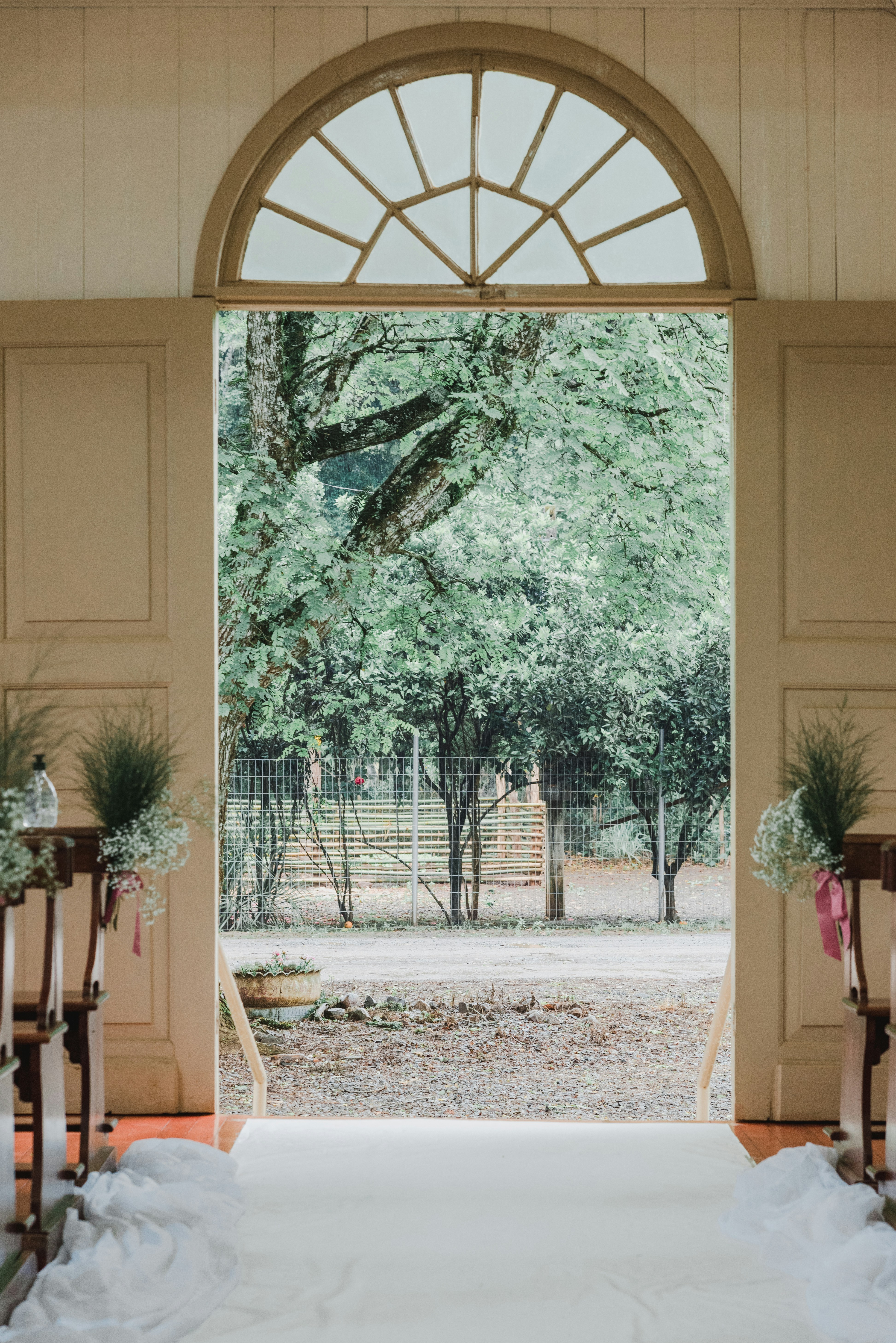 An open doorway looking out to green trees and a gravel path
