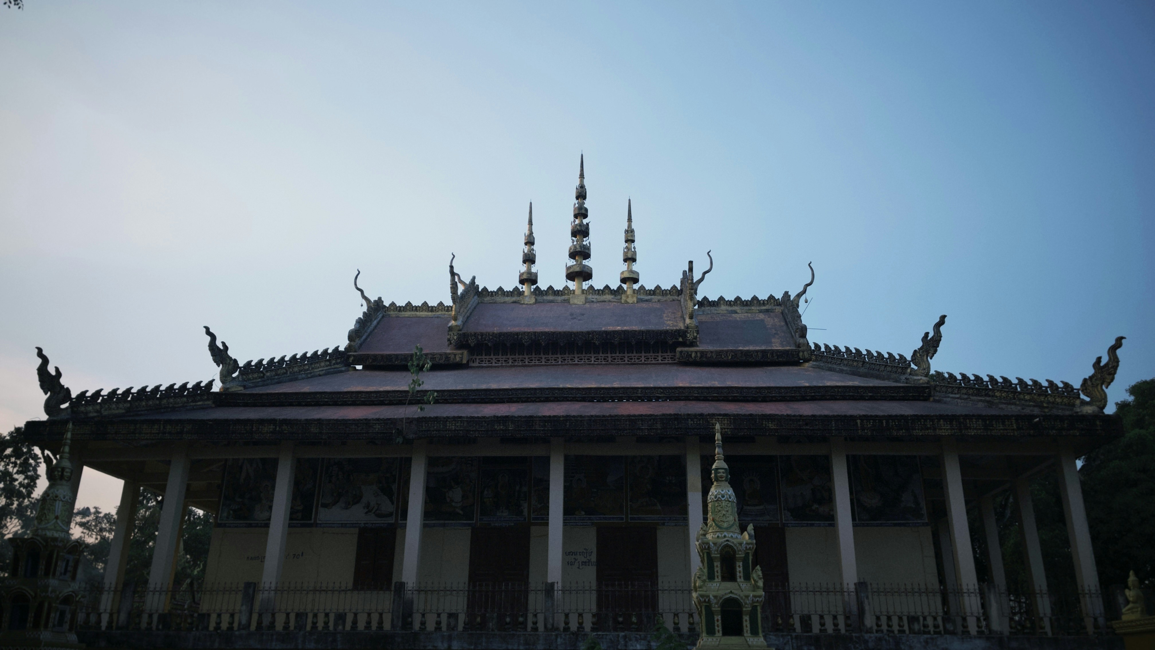 A Buddhist temple with a tiered roof and ornate spires against a clear sky