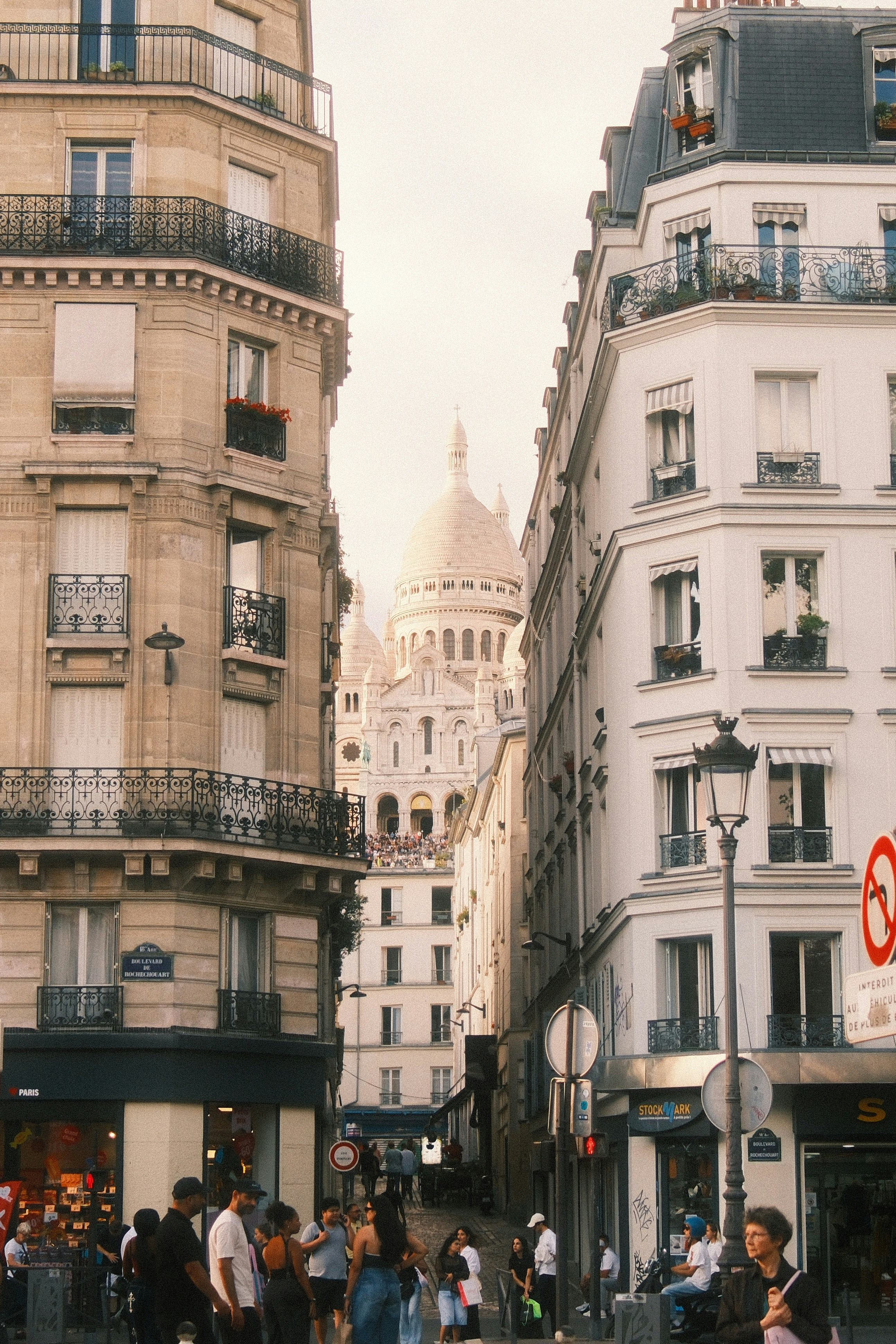 The Sacré-Cœur Basilica viewed from a street between two Parisian apartment buildings
