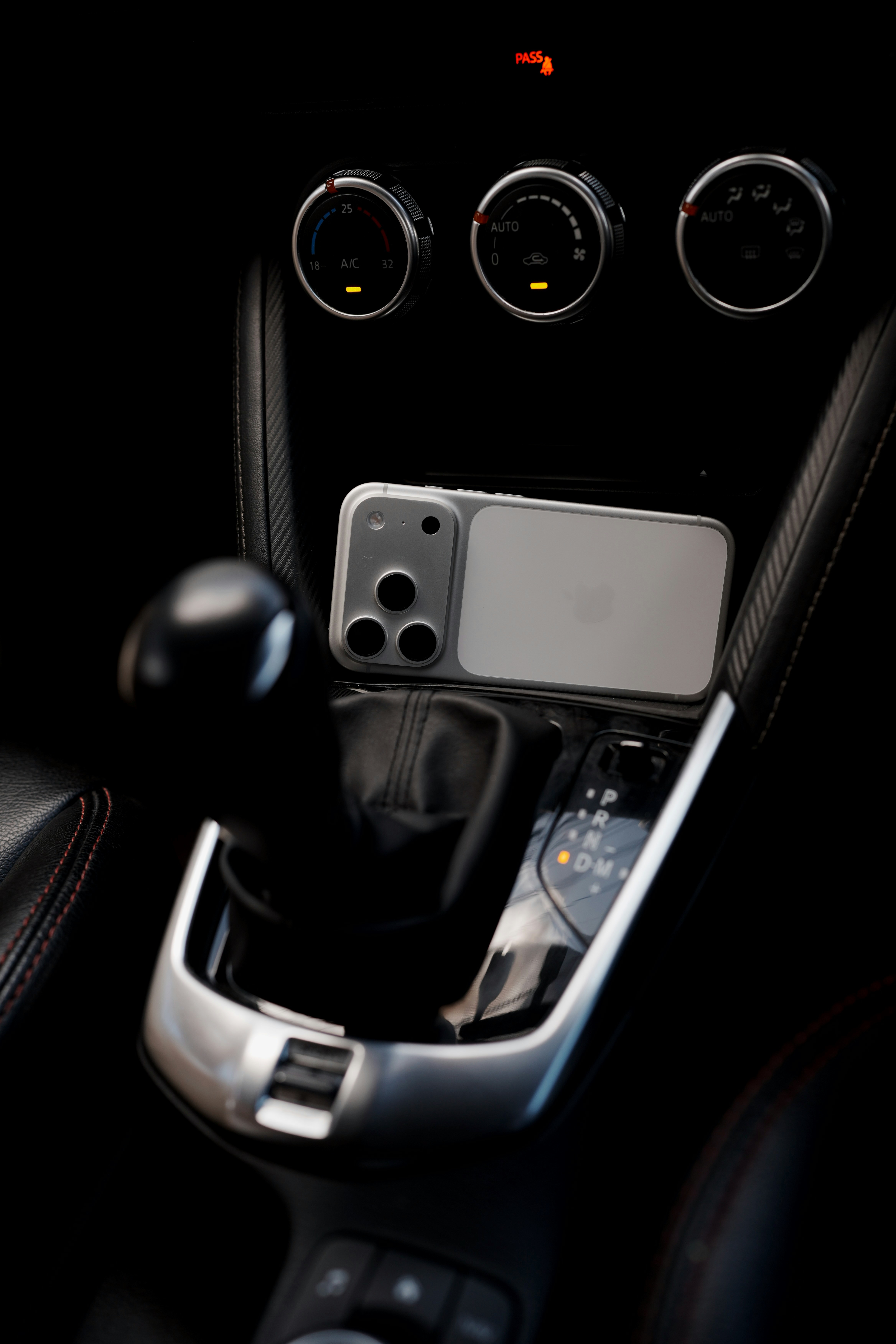 An iPhone displaying a GPS navigation app resting in a car center console next to a small plush bunny toy.