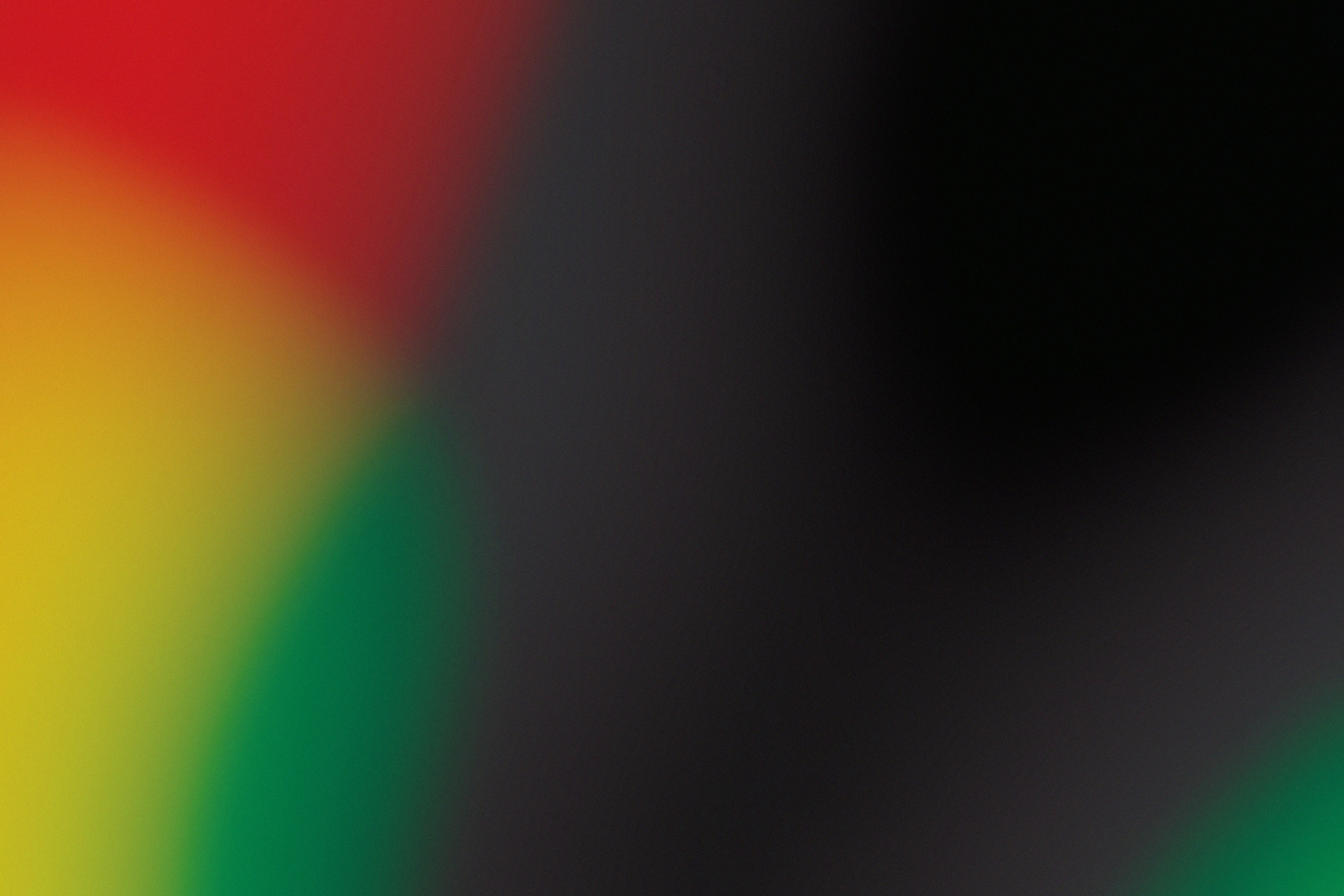 A soft abstract gradient of red, yellow, green, and black colors