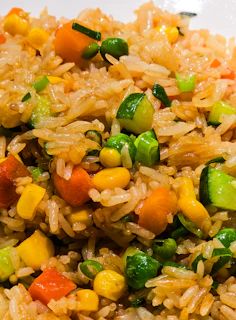 Fried rice with corn, carrots, peas, and diced zucchini in a close-up view
