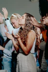 A group of people with hands raised in a room