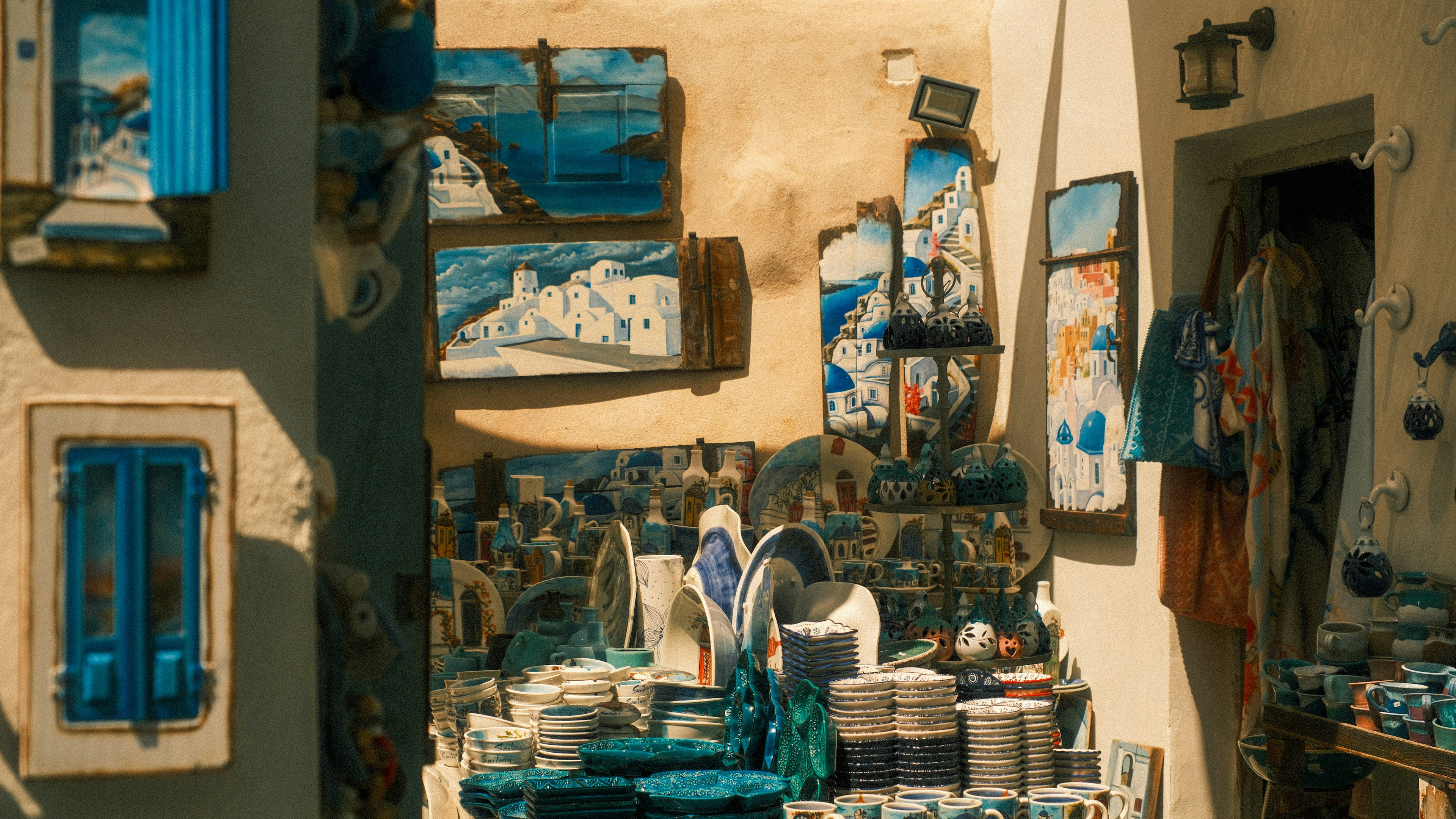 Ceramic plates and bowls with blue and white Santorini paintings in a shop