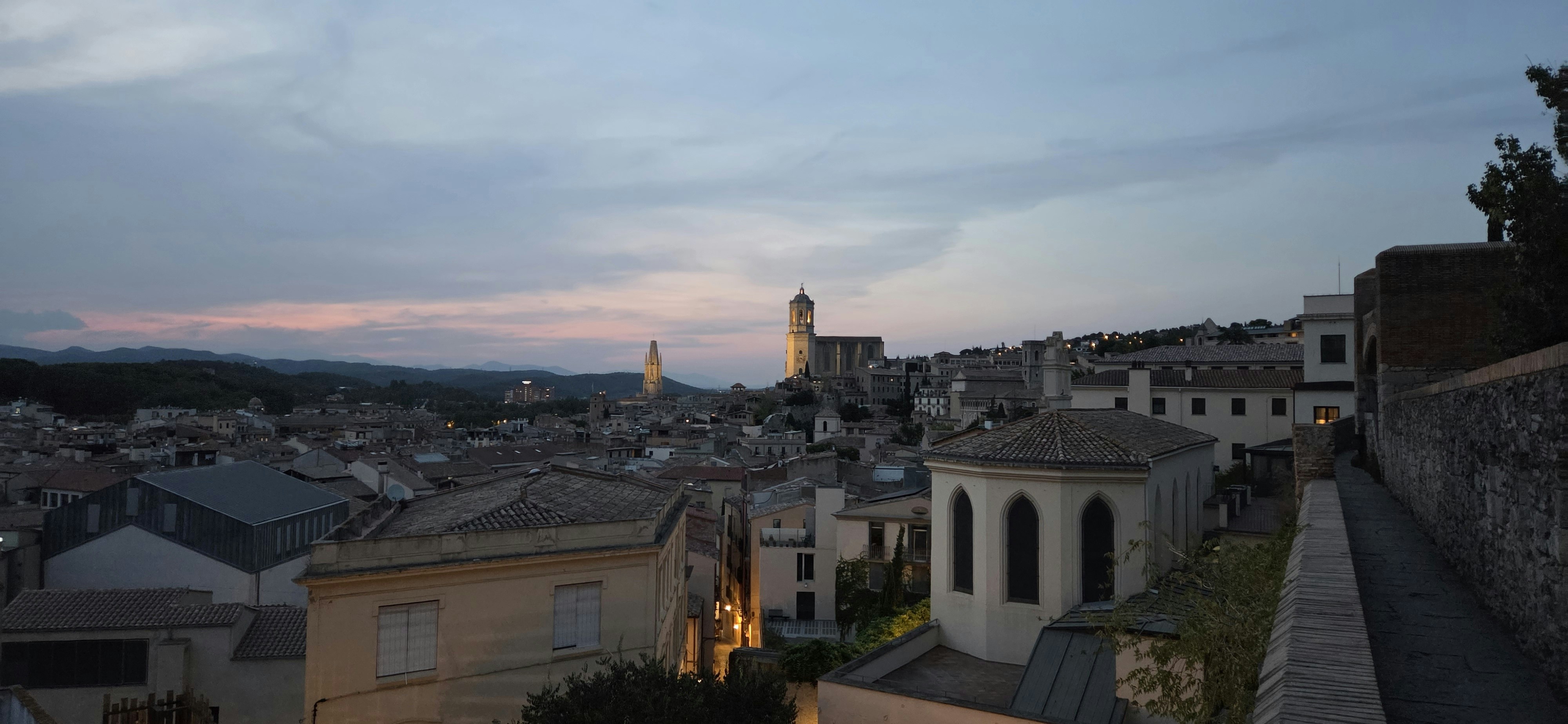 Die historische Skyline von Girona mit seiner Kathedrale ragt unter einem sanften Abendhimmel empor.