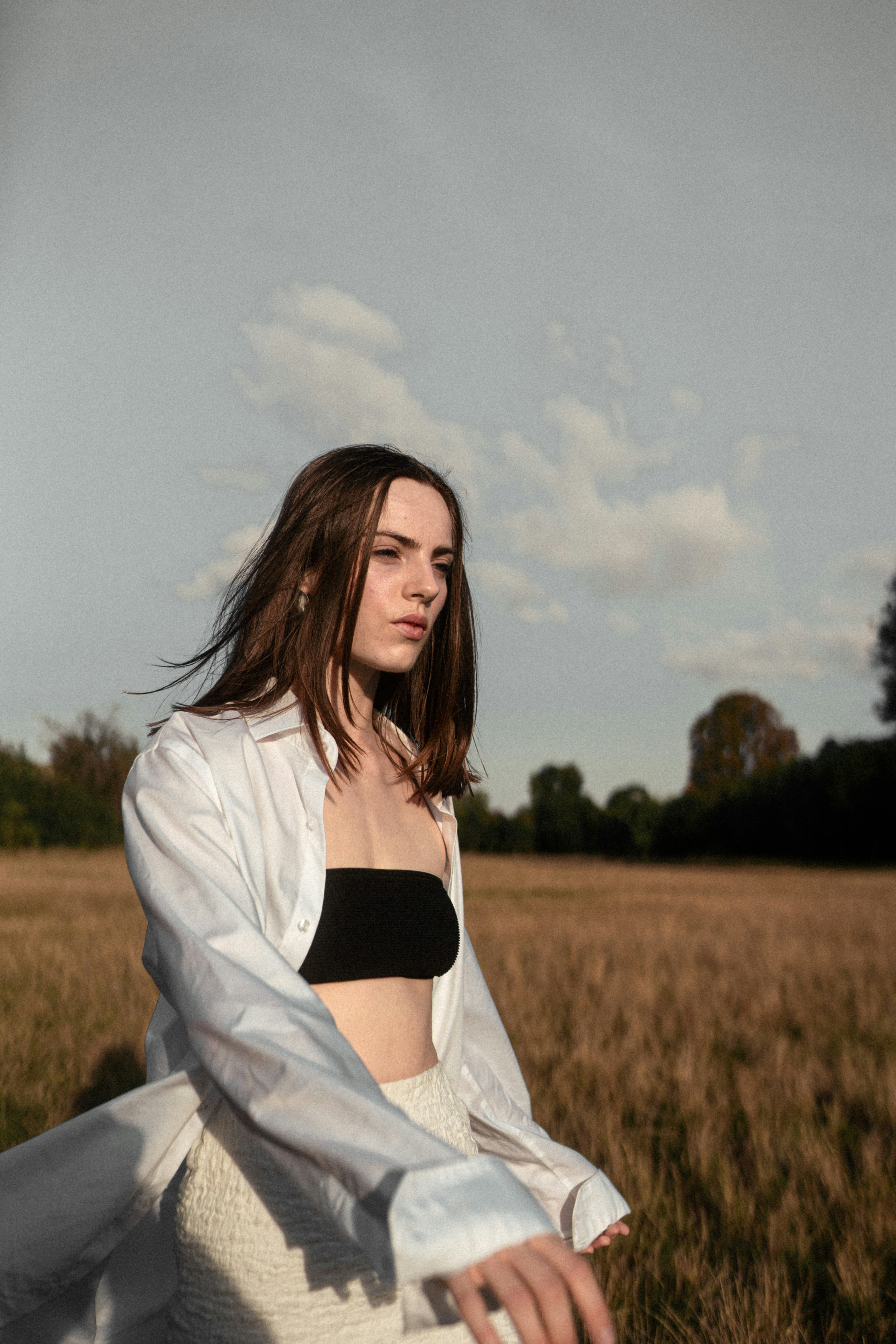 A person in a white shirt and black tube top in a golden field