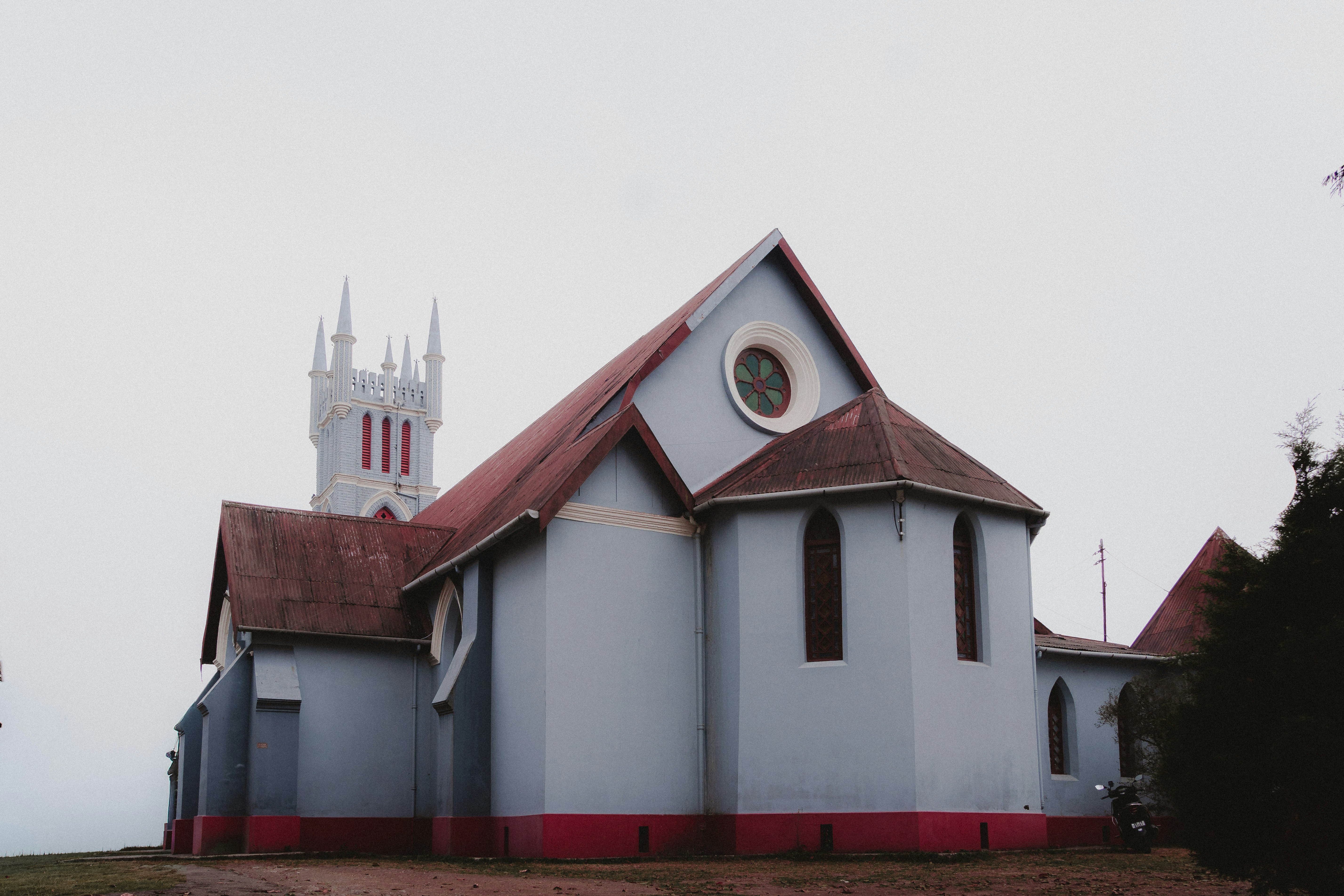 La iglesia Macfarlane Memorial de Kalimpong, de paredes azul claro y torre blanca con pináculos, bajo un cielo gris de invierno