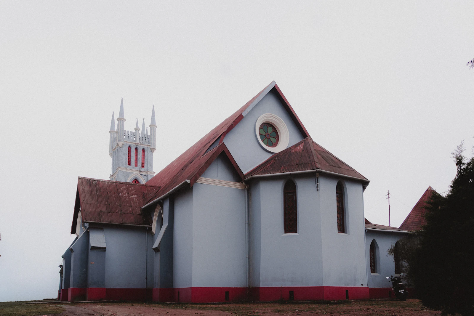 Macfarlane Memorial Church in Kalimpong, pale blue walls and a pinnacled white tower, under a grey winter sky