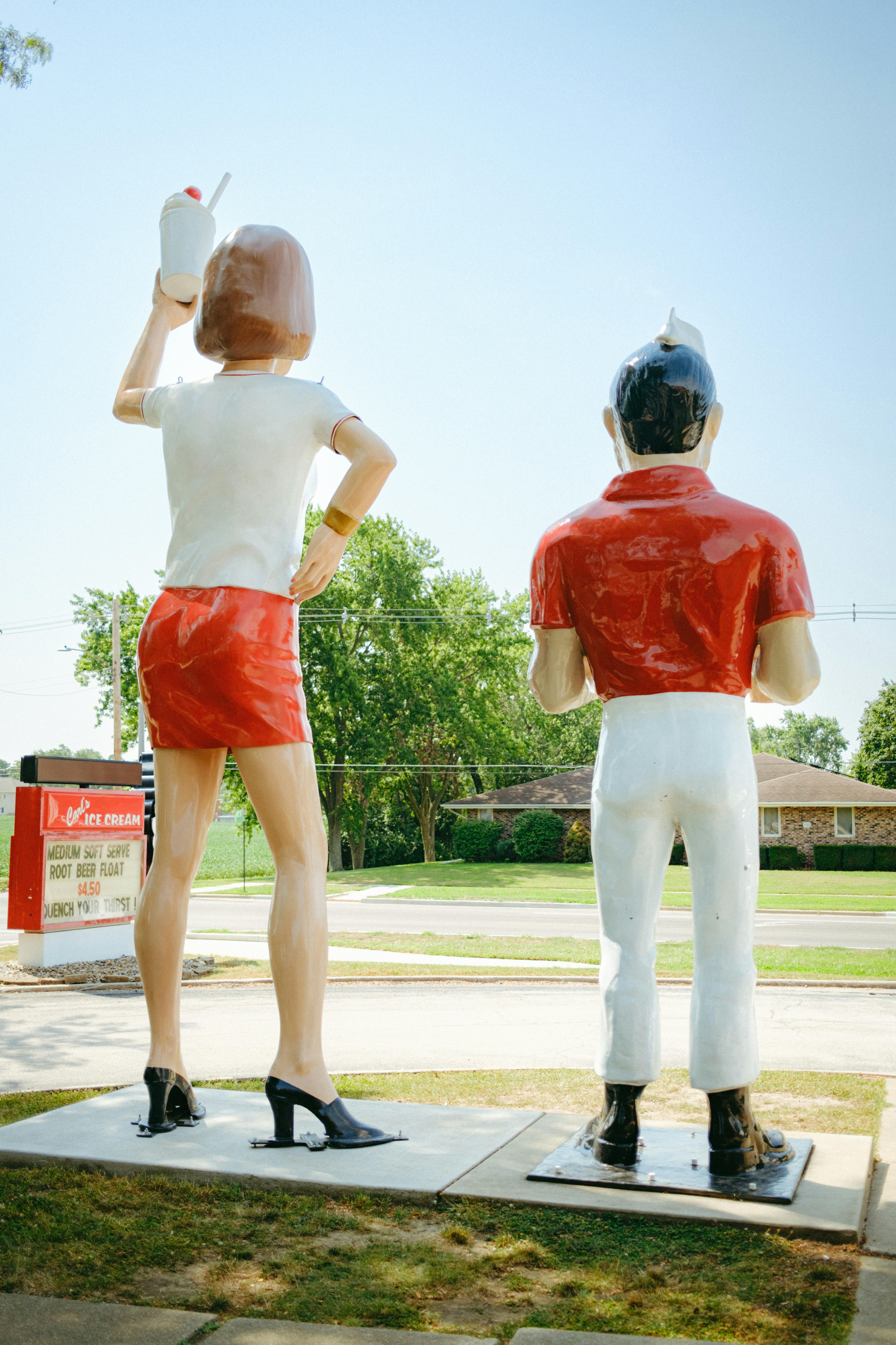 Two large fiberglass statues of a woman and a man standing outdoors