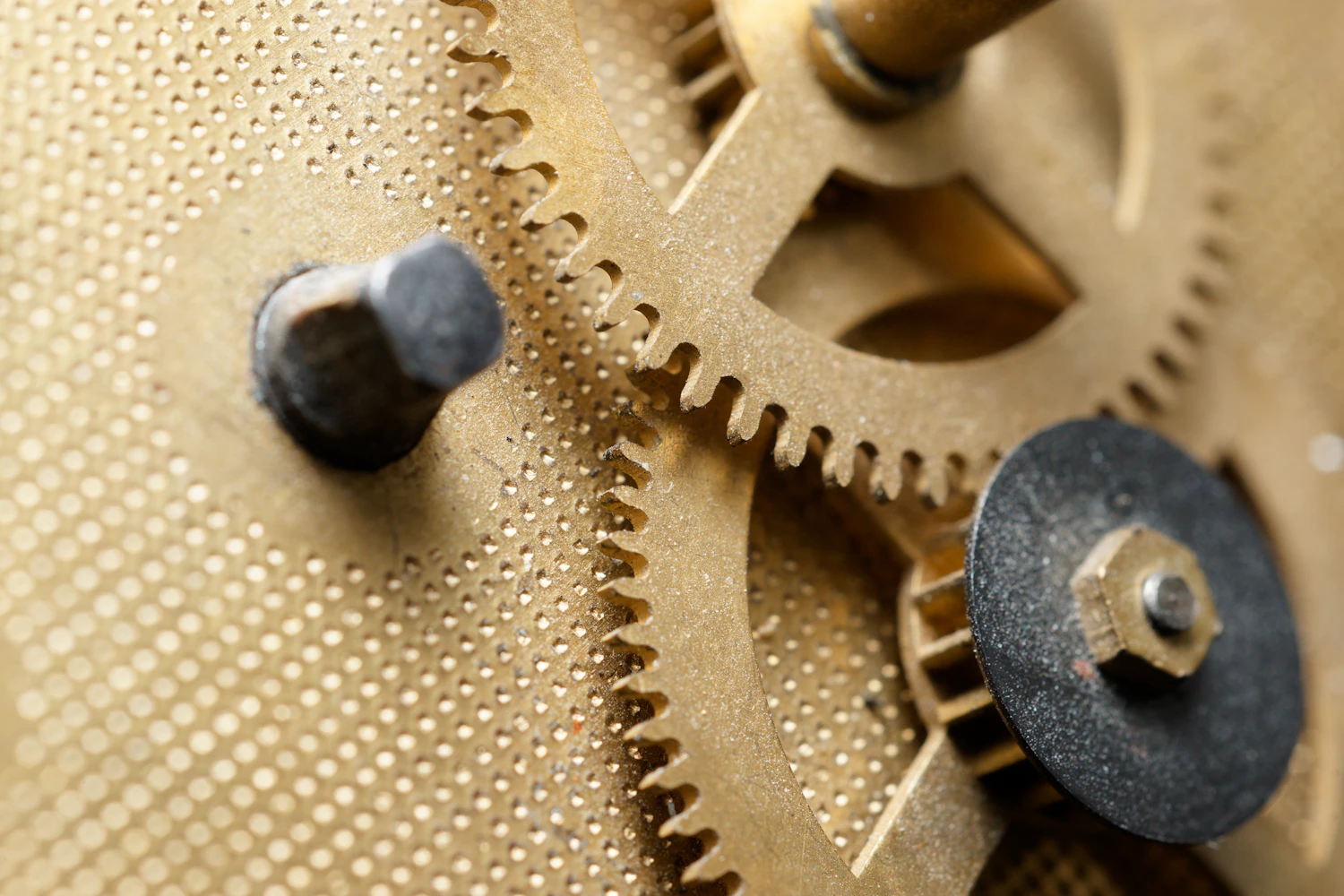 Brass clockwork gears meshing on a pierced plate inside a music box movement