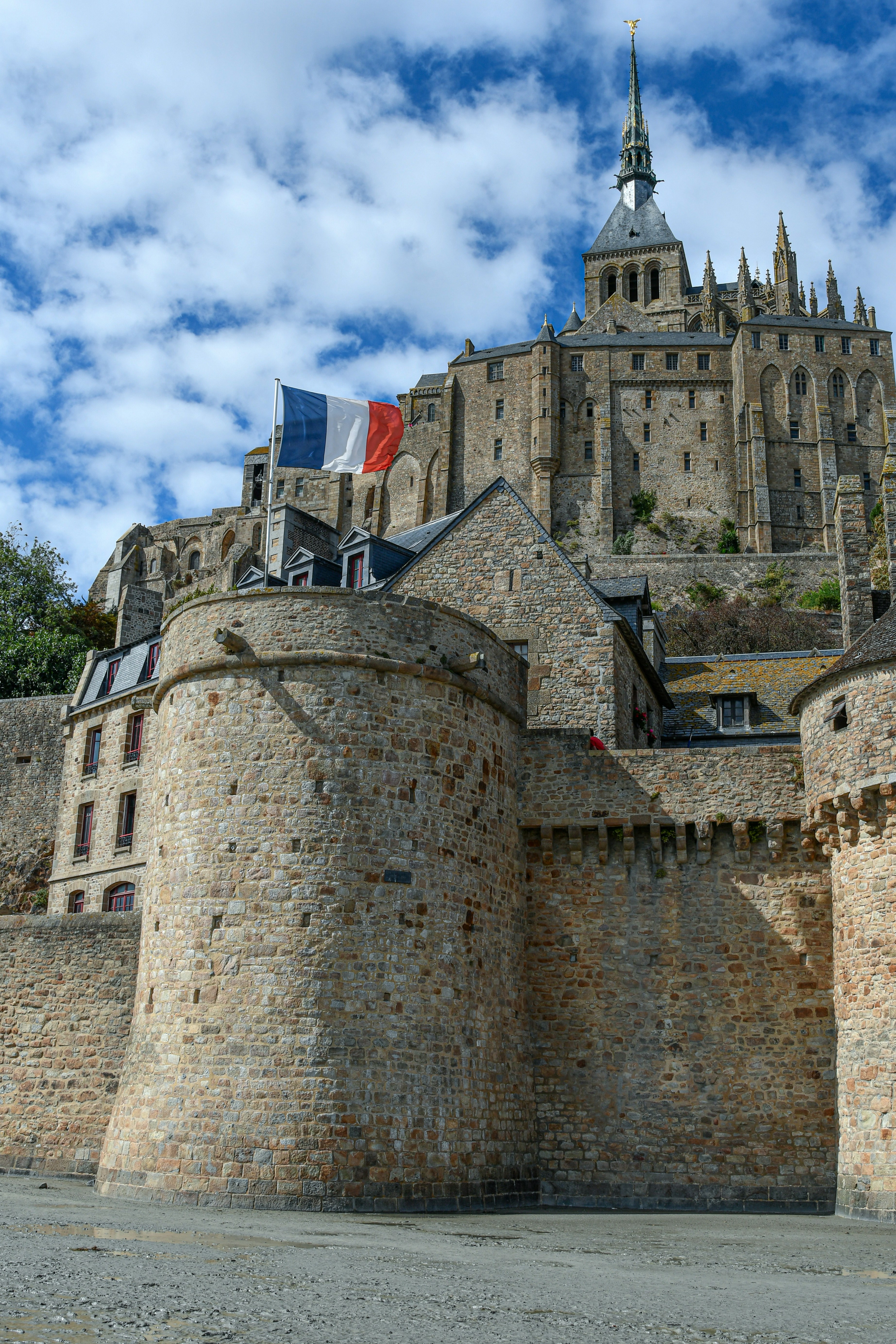 Die französische Flagge weht über den Steinmauern des Mont Saint-Michel in Frankreich