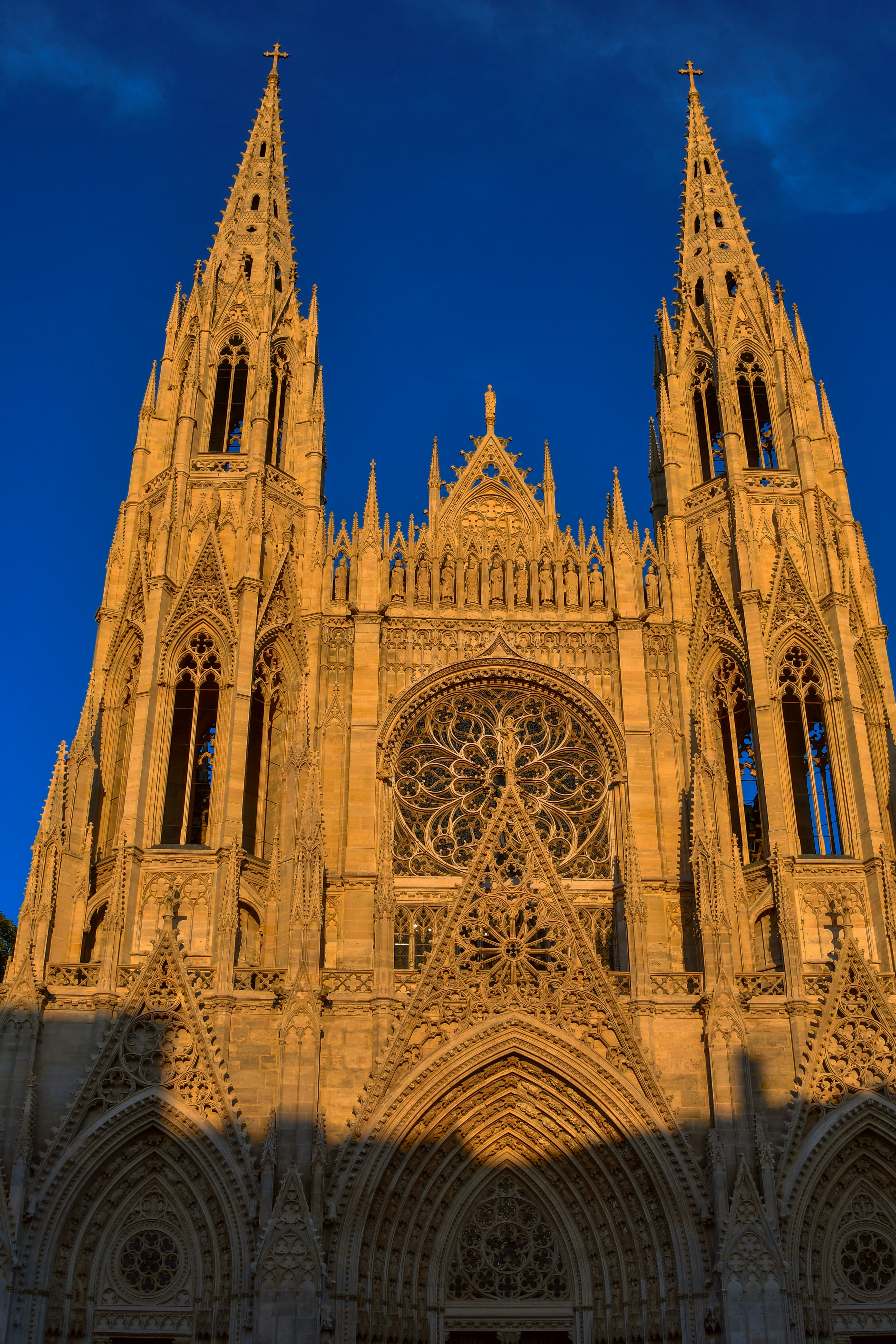 Gotische Kathedralfassade mit Zwillingstürmen und einem Rosettenfenster im goldenen Licht