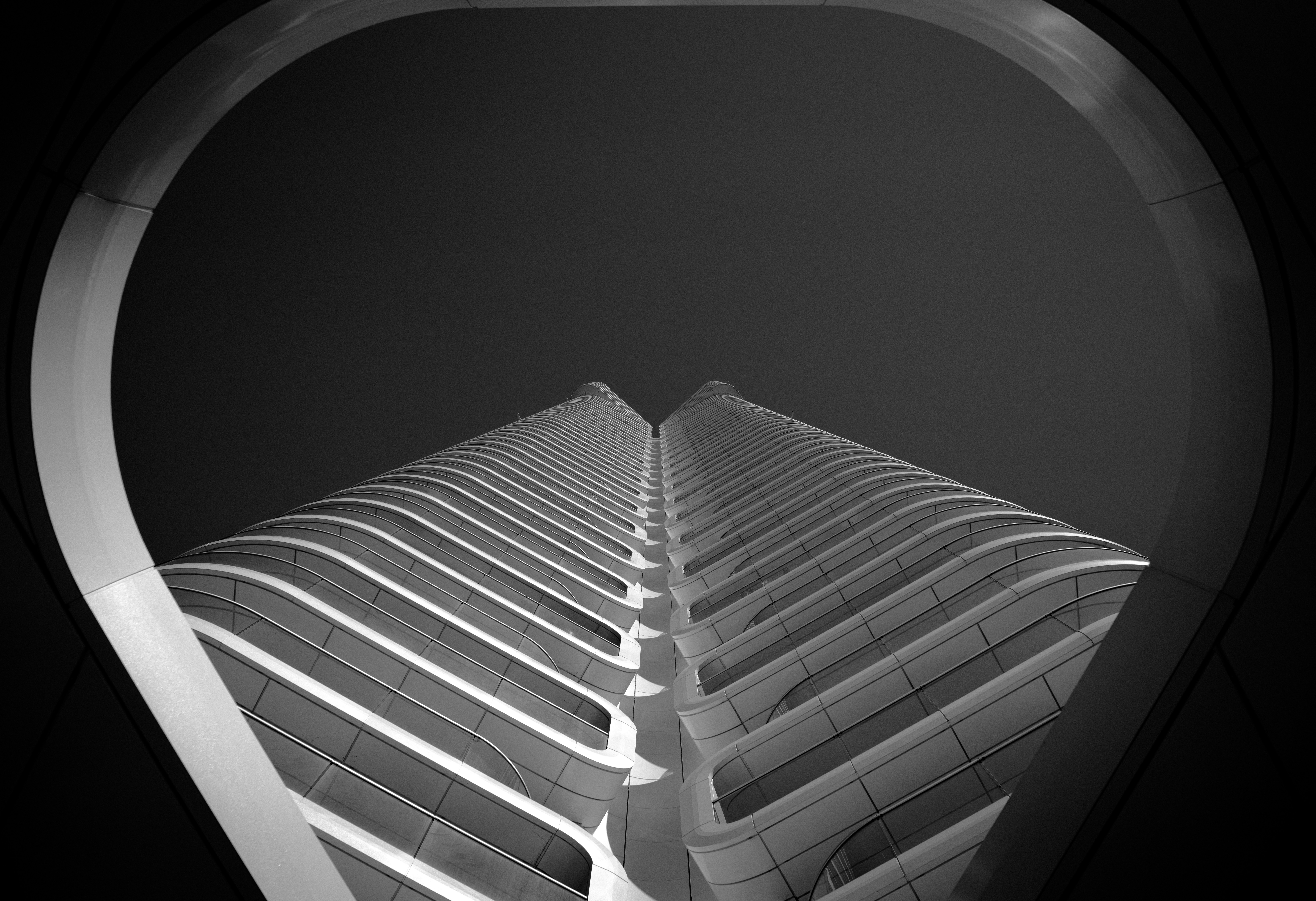 A low-angle view of a modern skyscraper in Frankfurt framed by a circular arch