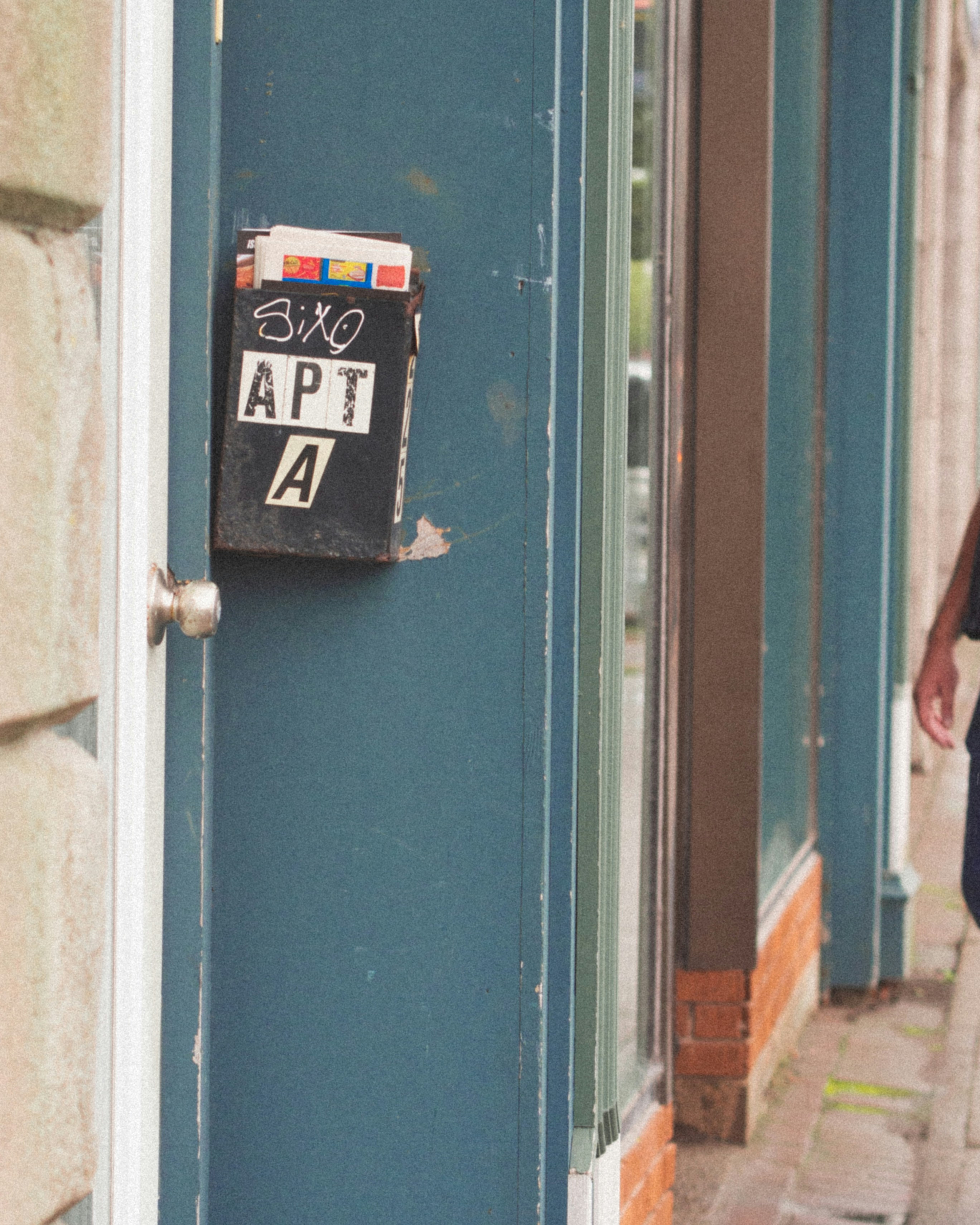 Black metal mailbox labeled Apt A on a blue door frame, a small clue landlords in Tennessee watch when a tenant may have skipped
